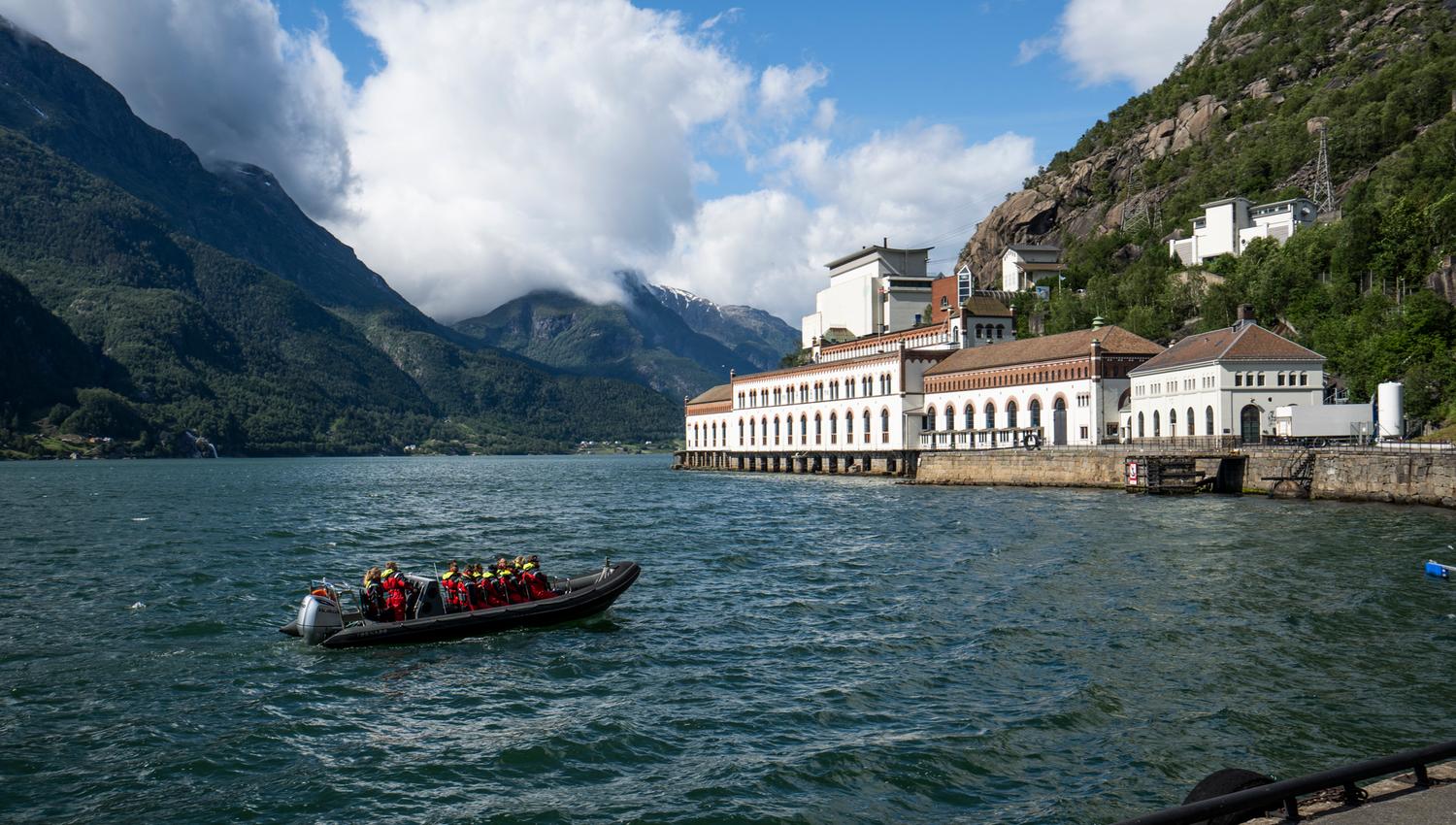 A RIB boat by an iconic industrial heritage building along the Hardangerfjord.