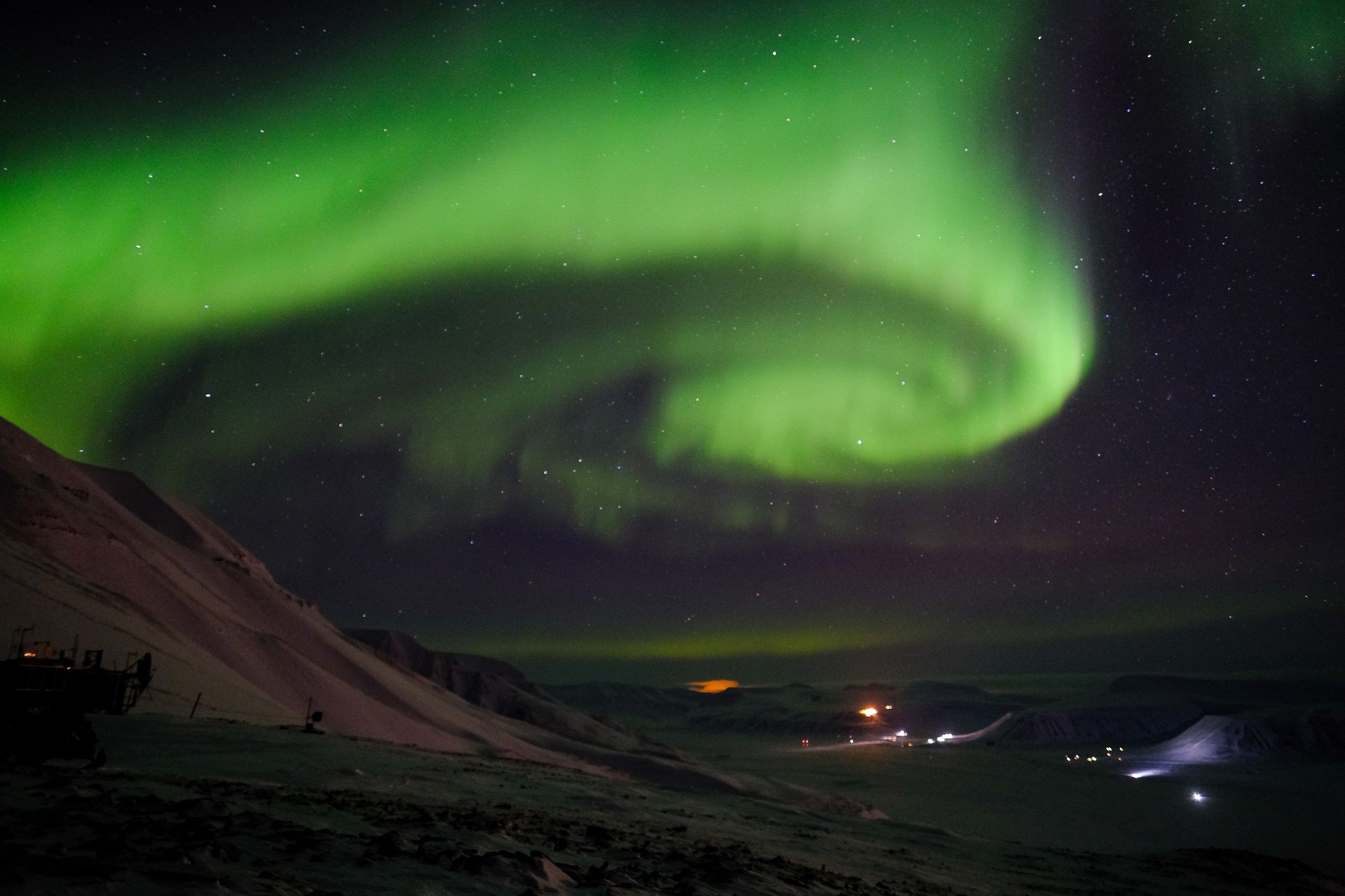 En hvirvel av nordlys på himmelen over en dal