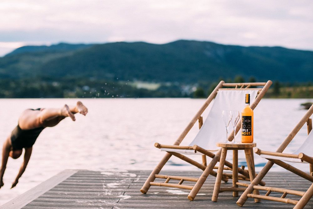 jente hopper i vannet fra brygga til Heit Telemark sauna ved Lien Gård