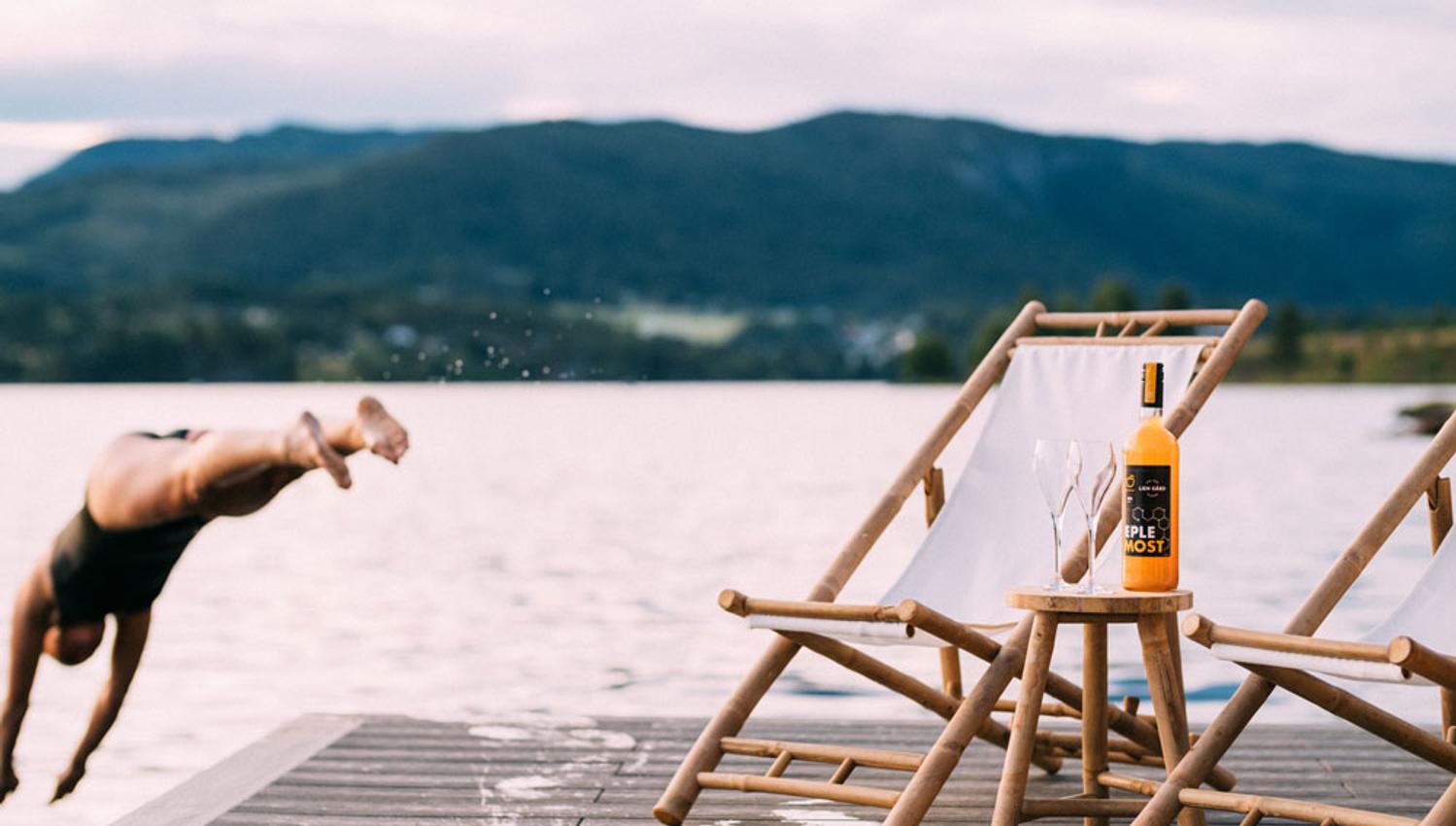 jente hopper i vannet fra brygga til Heit Telemark sauna ved Lien Gård