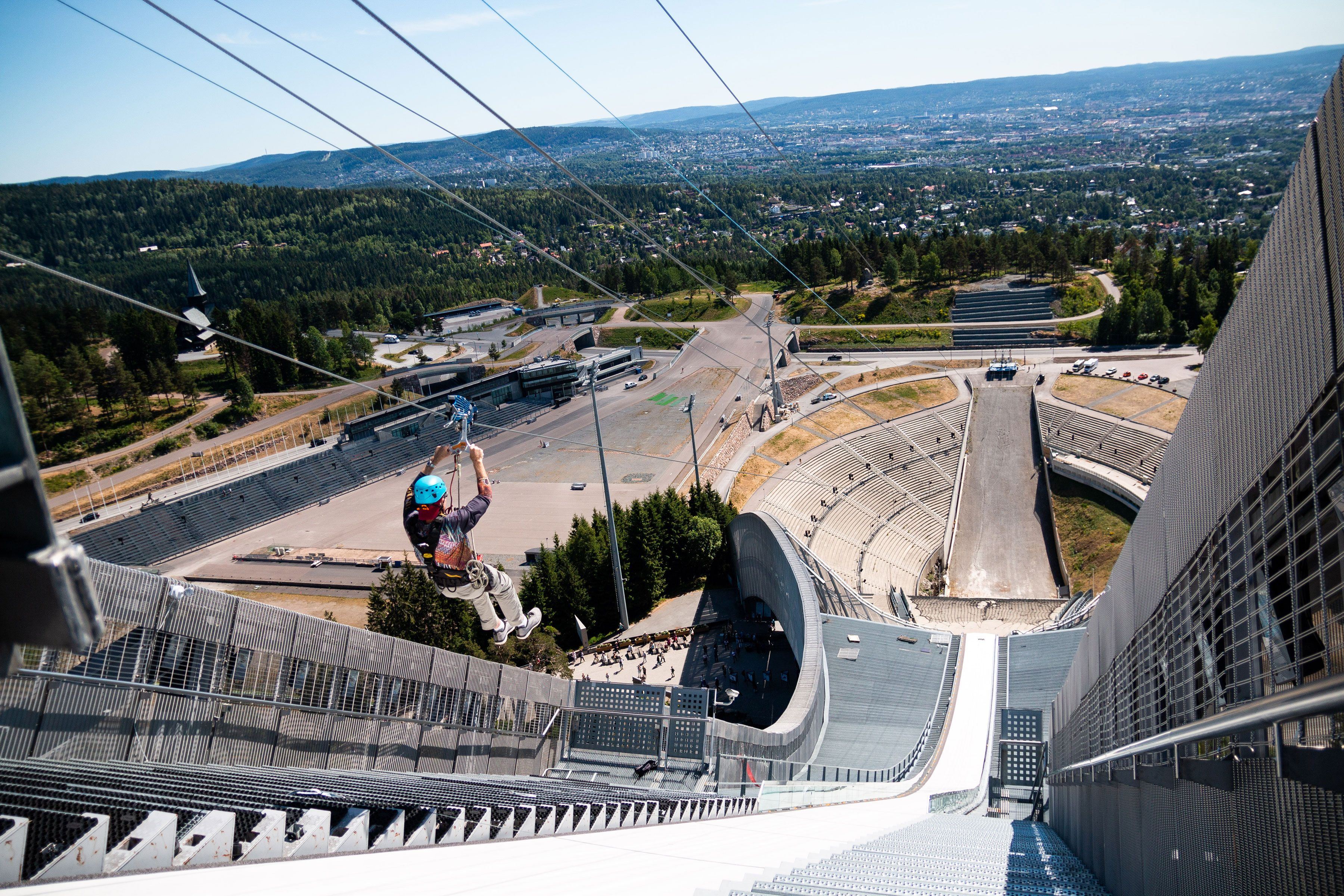 En person som zipliner nedover Holmenkollbakken.