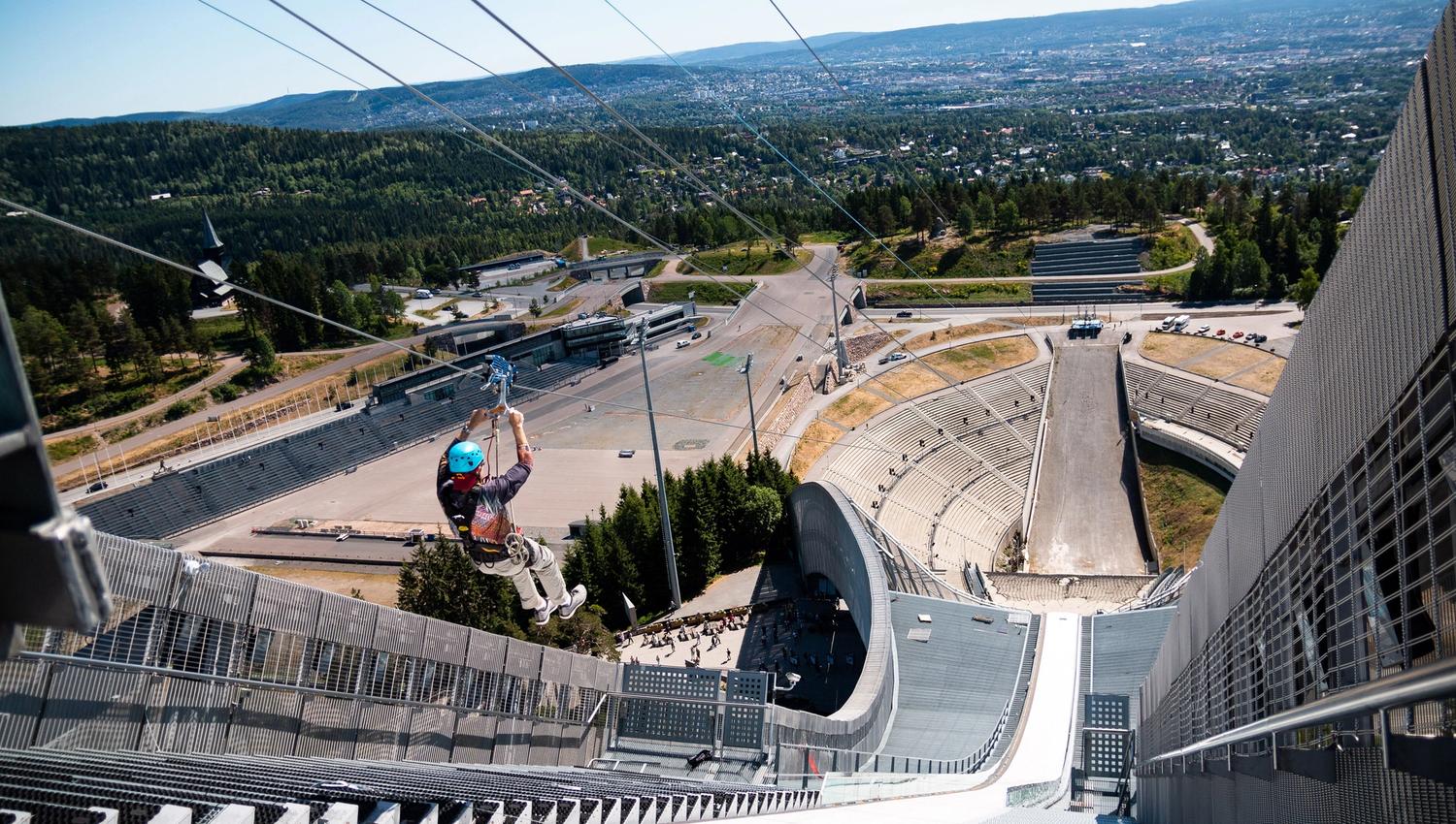 En person som zipliner nedover Holmenkollbakken.