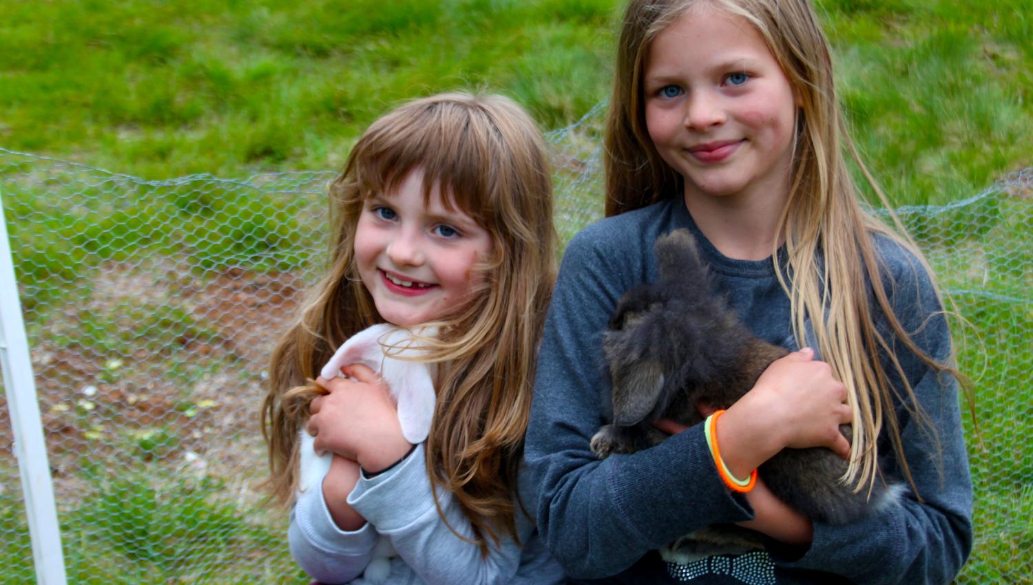 2 fornøyde jenter koser med kaninene på Holsingseteren