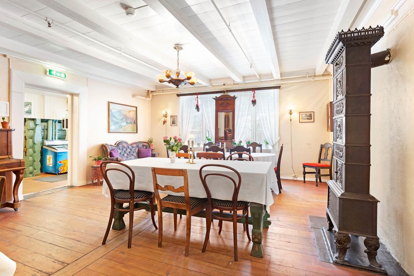 Elegant spisestove med antikke møblar og piano på Jaunsen Gjestgjevarstad i Hardanger.