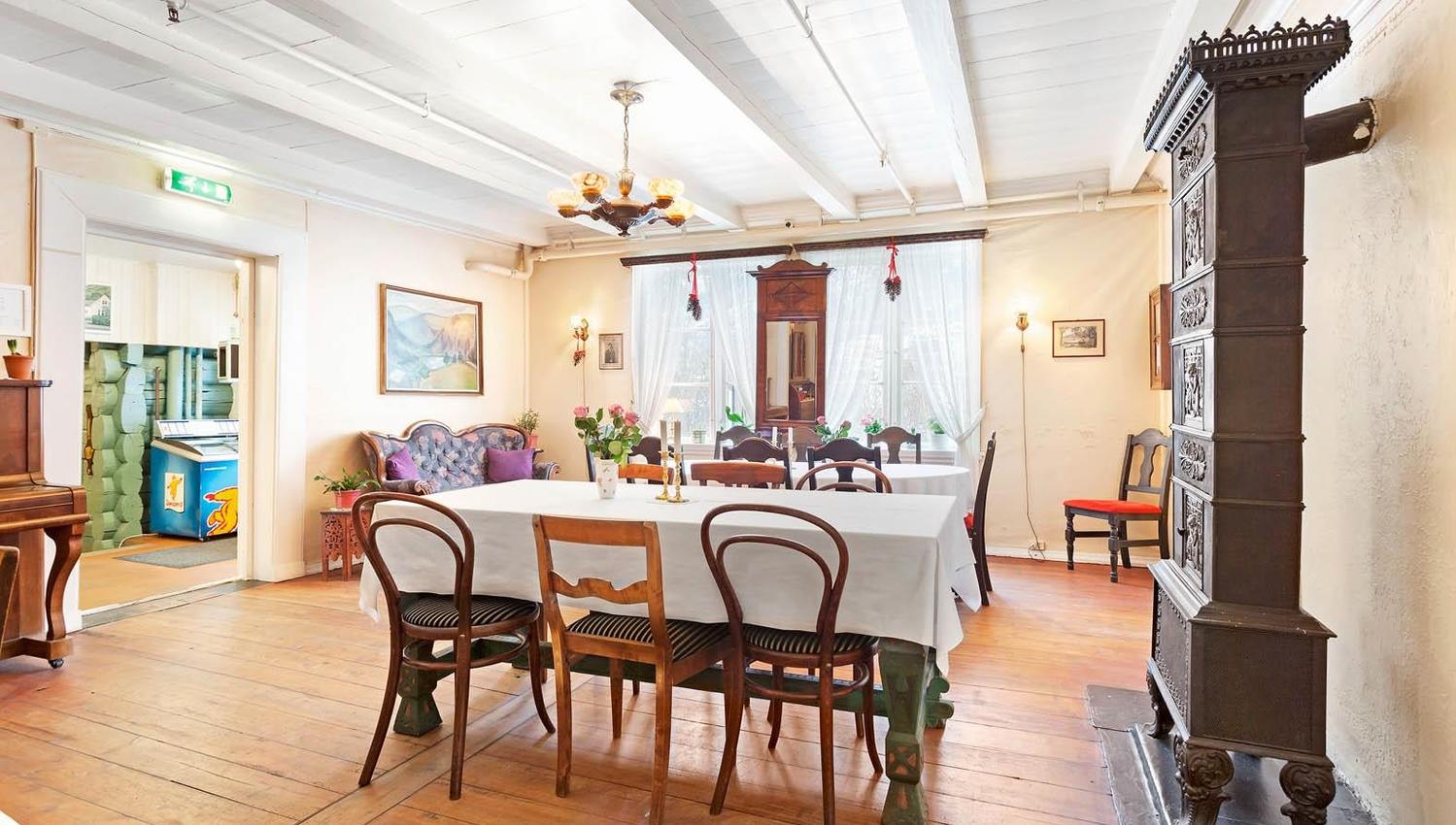 Elegant dining room with antique furniture and piano at Jaunsen Guesthouse in Hardanger.
