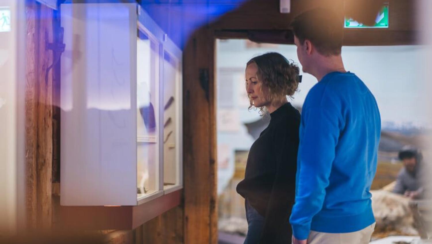 To personer ser på en utstilling på Polarmuseet i Tromsø