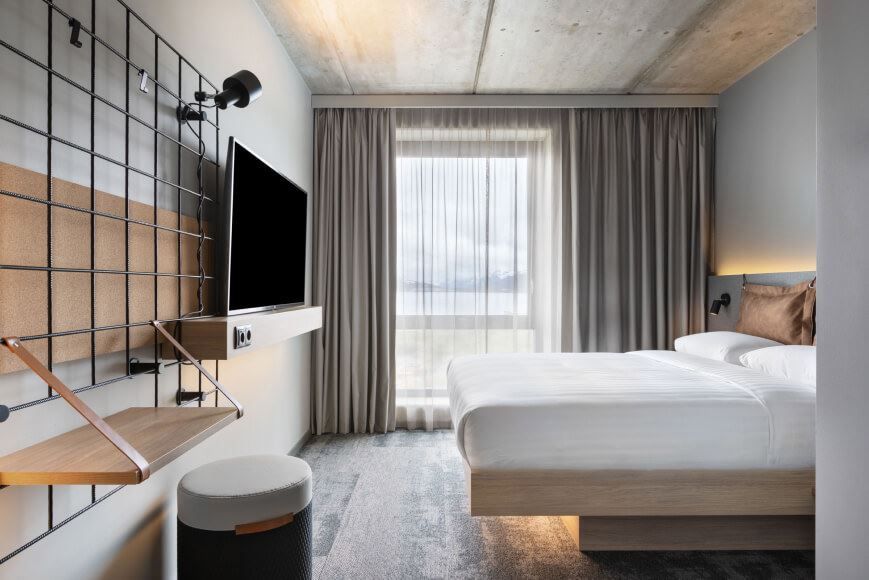 Bedroom with TV, bed and window with a view over Tromsø.