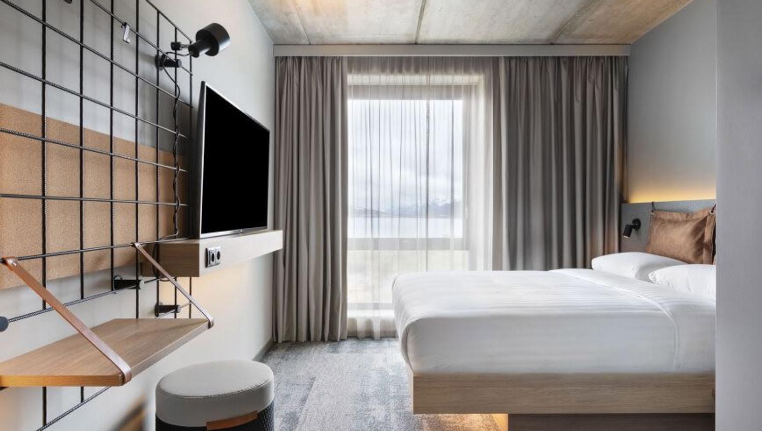 Bedroom with TV, bed and window with a view over Tromsø.