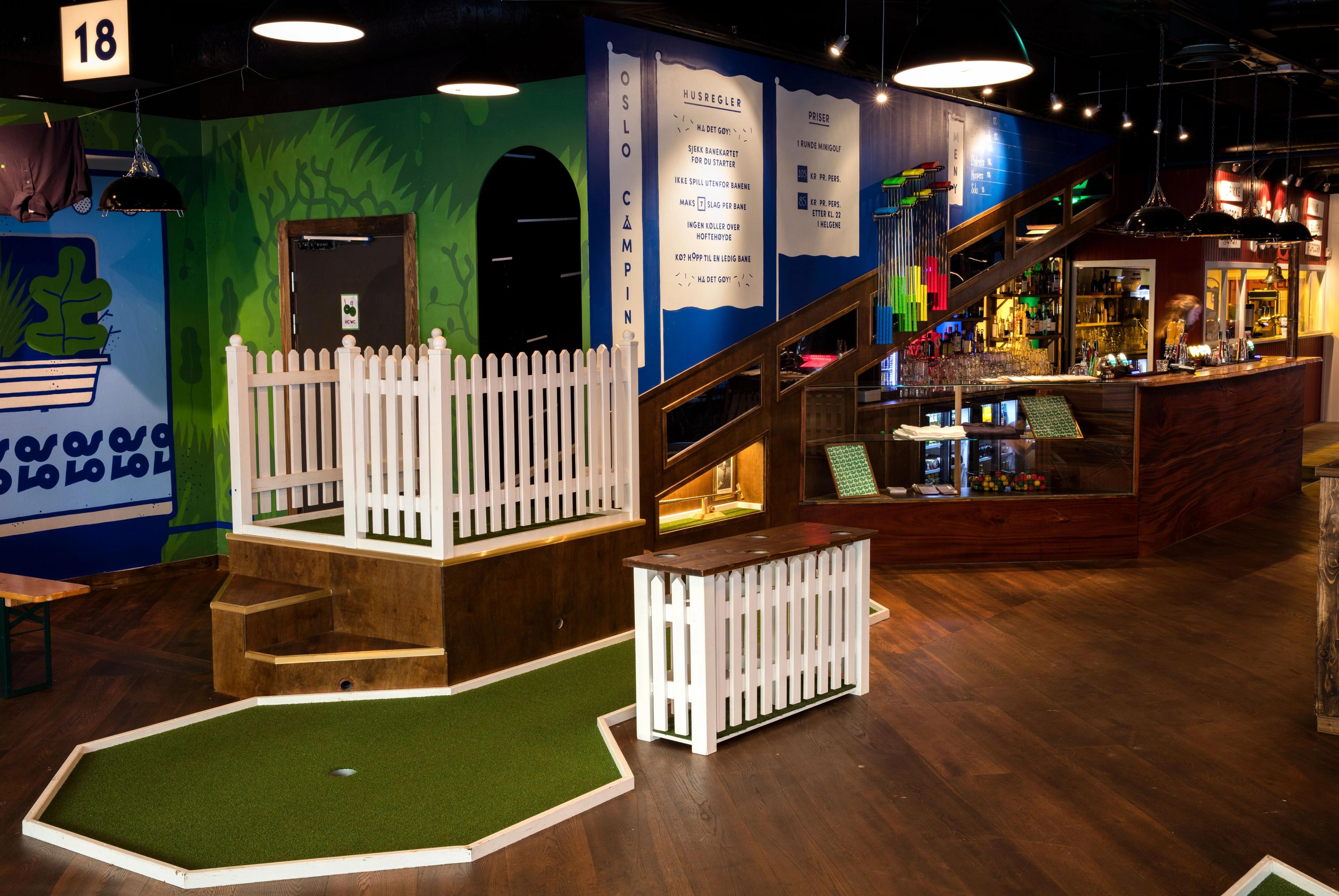 Interior: mini golf course with bar in the background