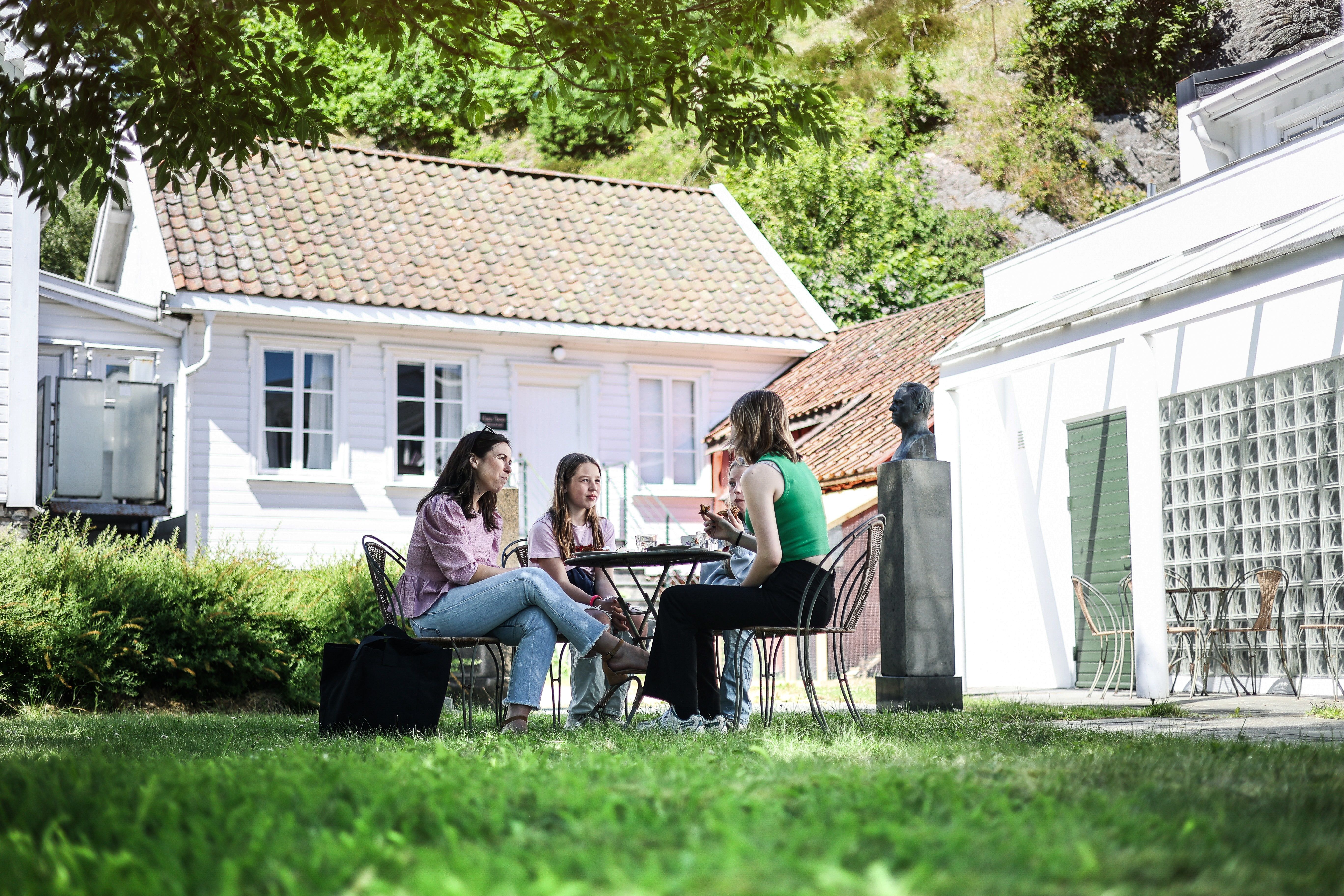 En gjeng sitter rundt på et piknik bord og spiser