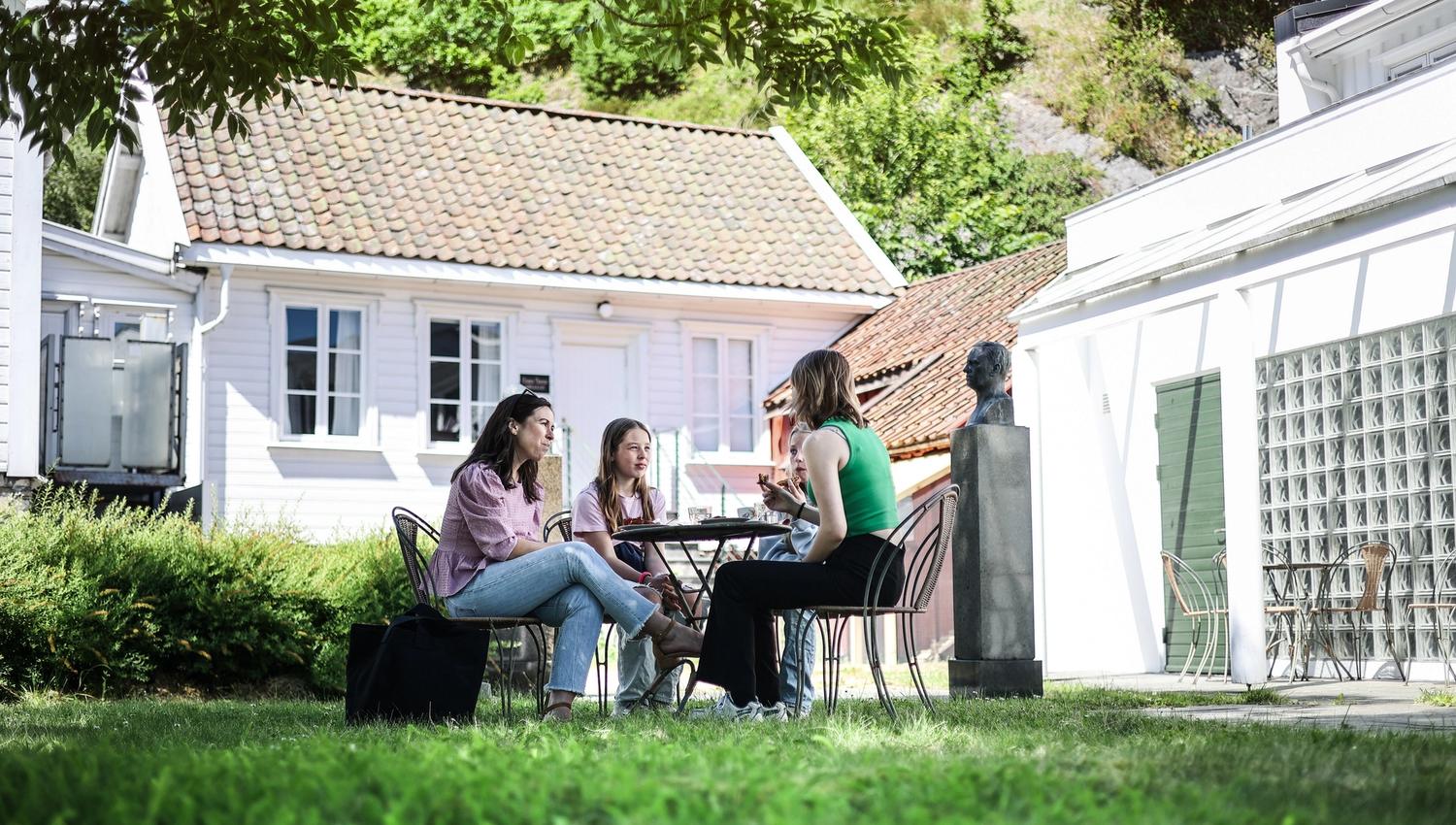 En gjeng sitter rundt på et piknik bord og spiser