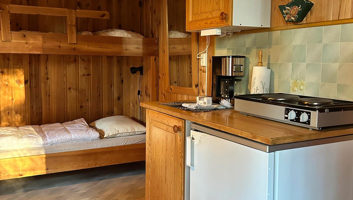 Inne i hytta, køyeseng og kjøkken