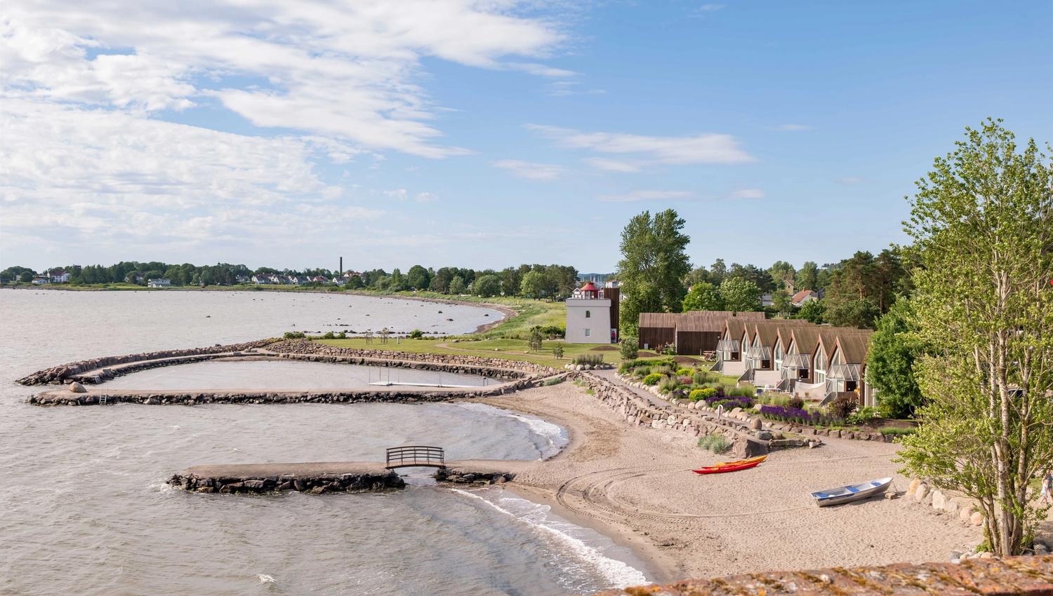Oversiktsbilde over strand og hytter