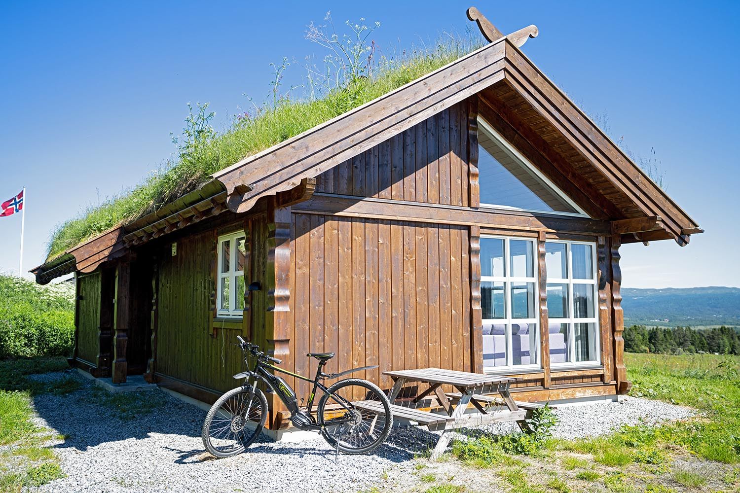 Cabin with grass roof and a bicycle parked outside