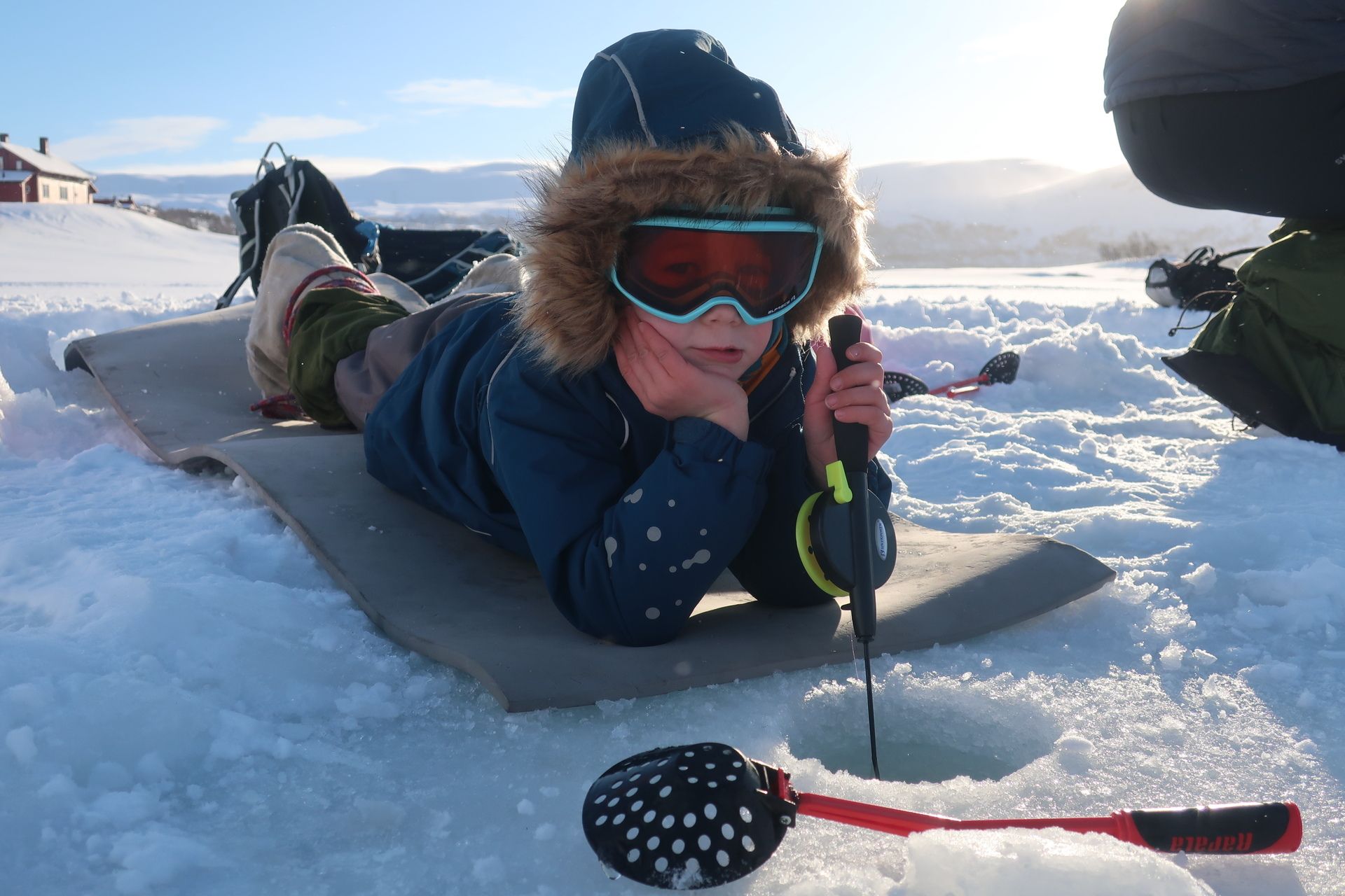 Kid waits to see what she can  catch in front of the ice cave.