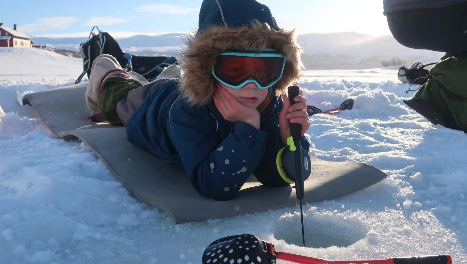 Kid waits to see what she can catch in front of the ice cave.