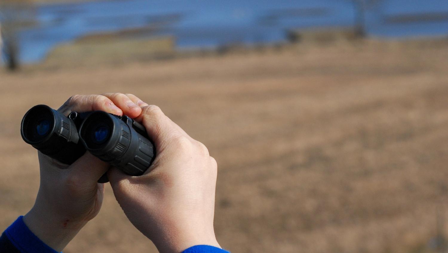 person looking with binoculars
