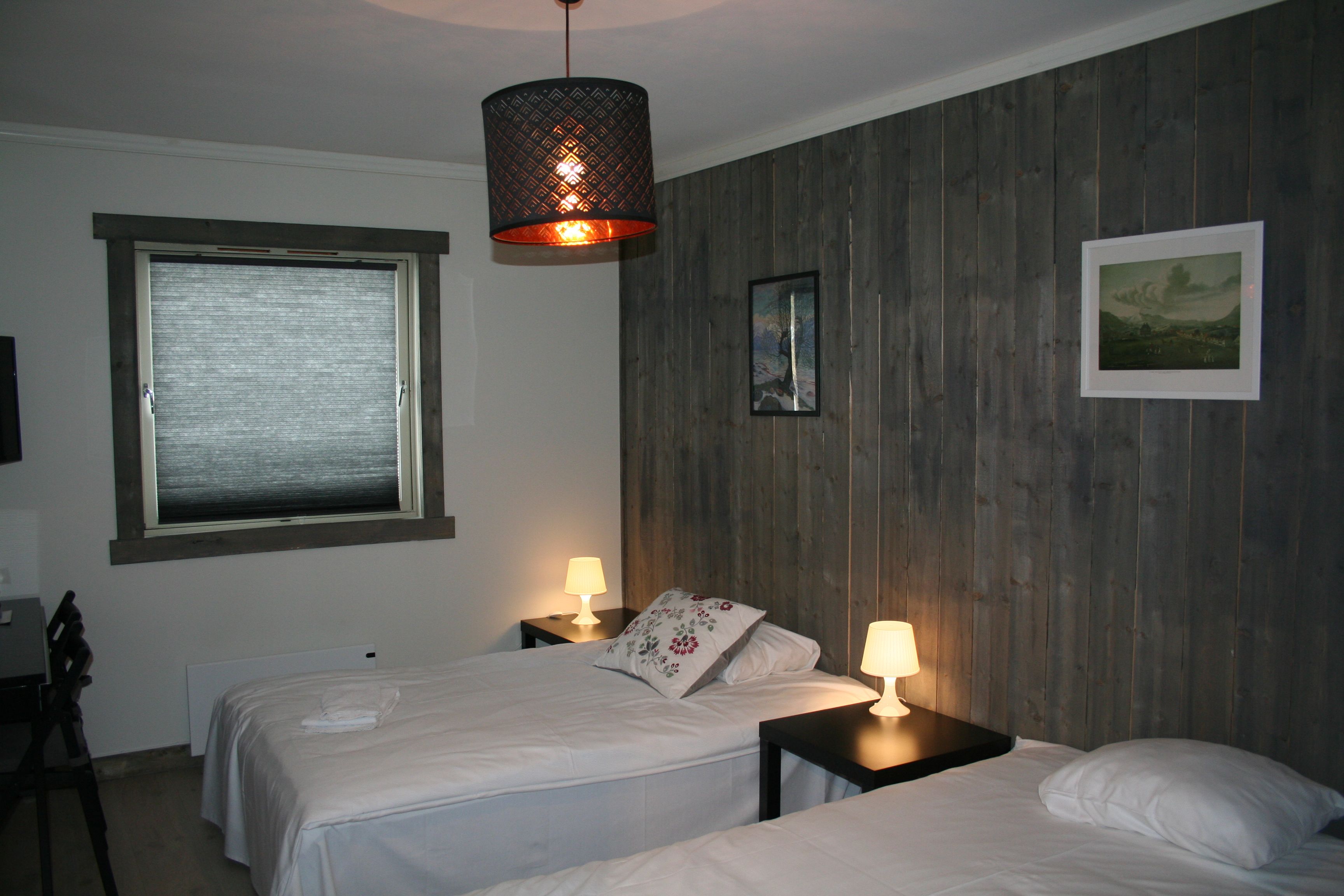 Komfortabelt dobbeltrom på Kvamseter Lodge i Hardanger, med to enkeltsenger og roleg atmosfære.