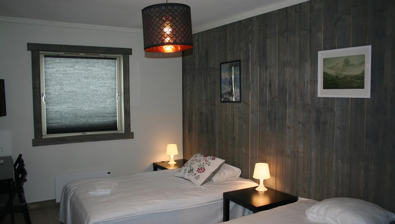 Komfortabelt dobbeltrom på Kvamseter Lodge i Hardanger, med to enkeltsenger og roleg atmosfære.