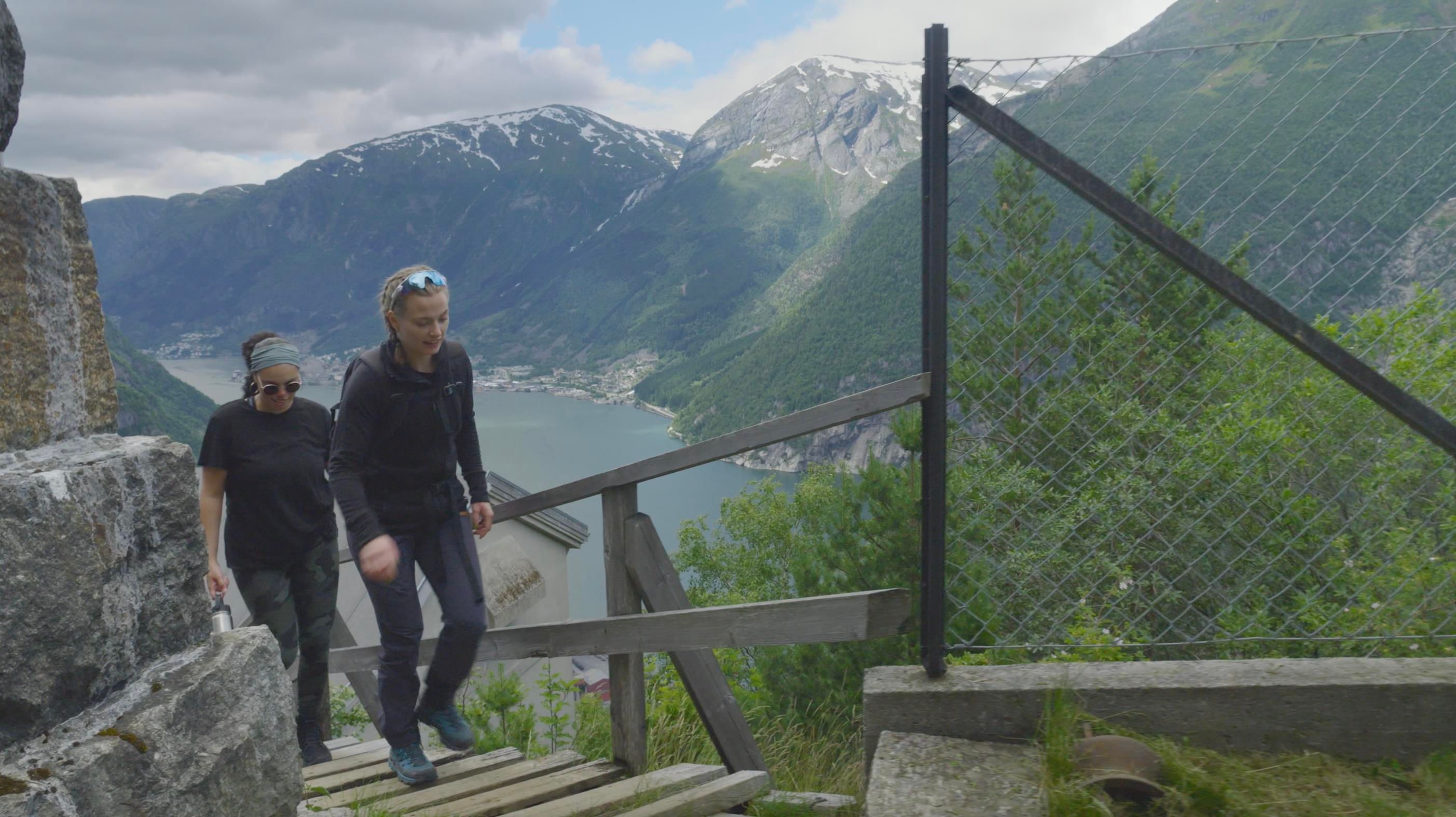 To turgåarar på veg opp til Lilletopp, med spektakulær utsikt over fjorden og fjella.