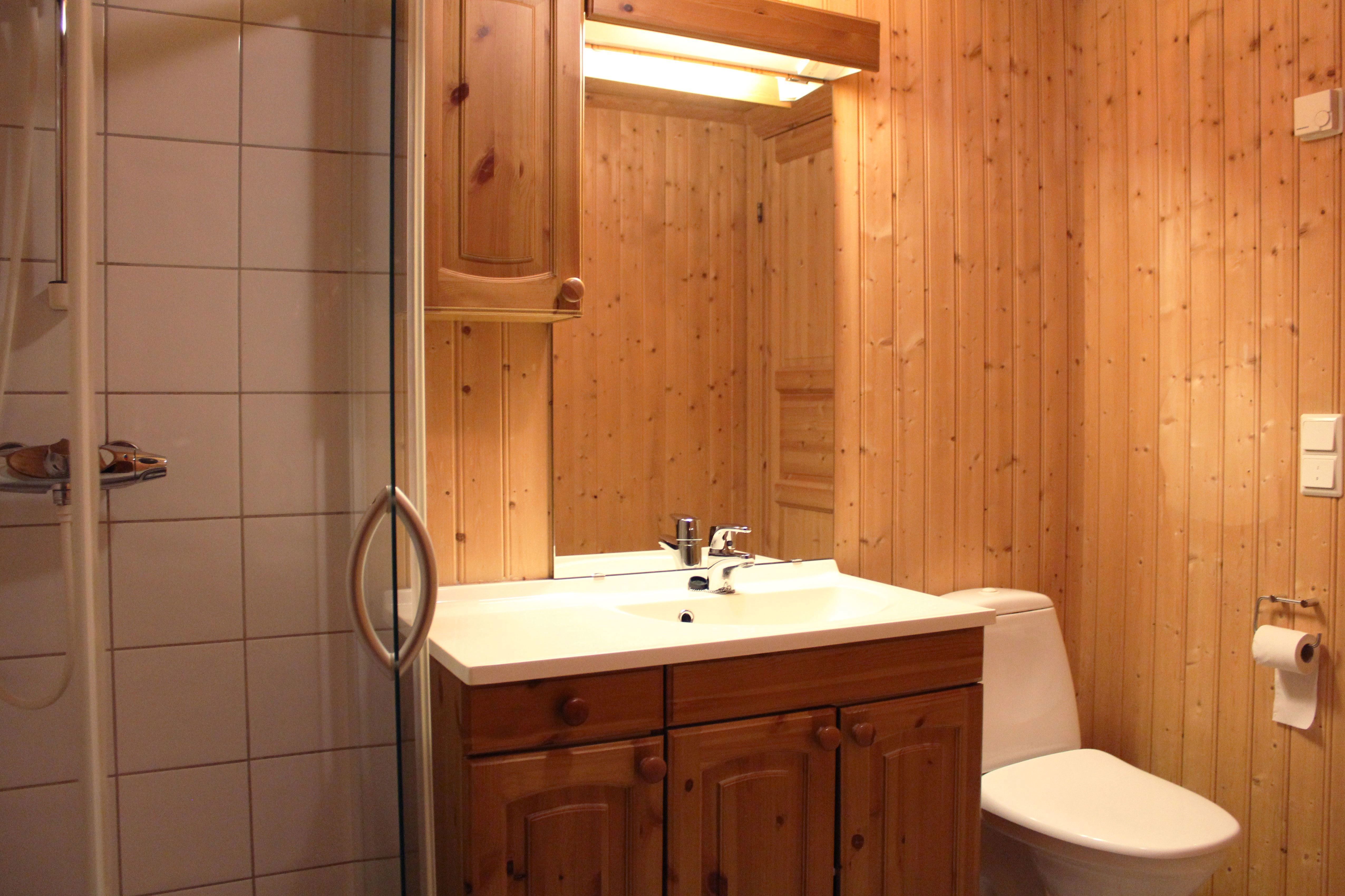 A bathroom with wooden wall and sink.