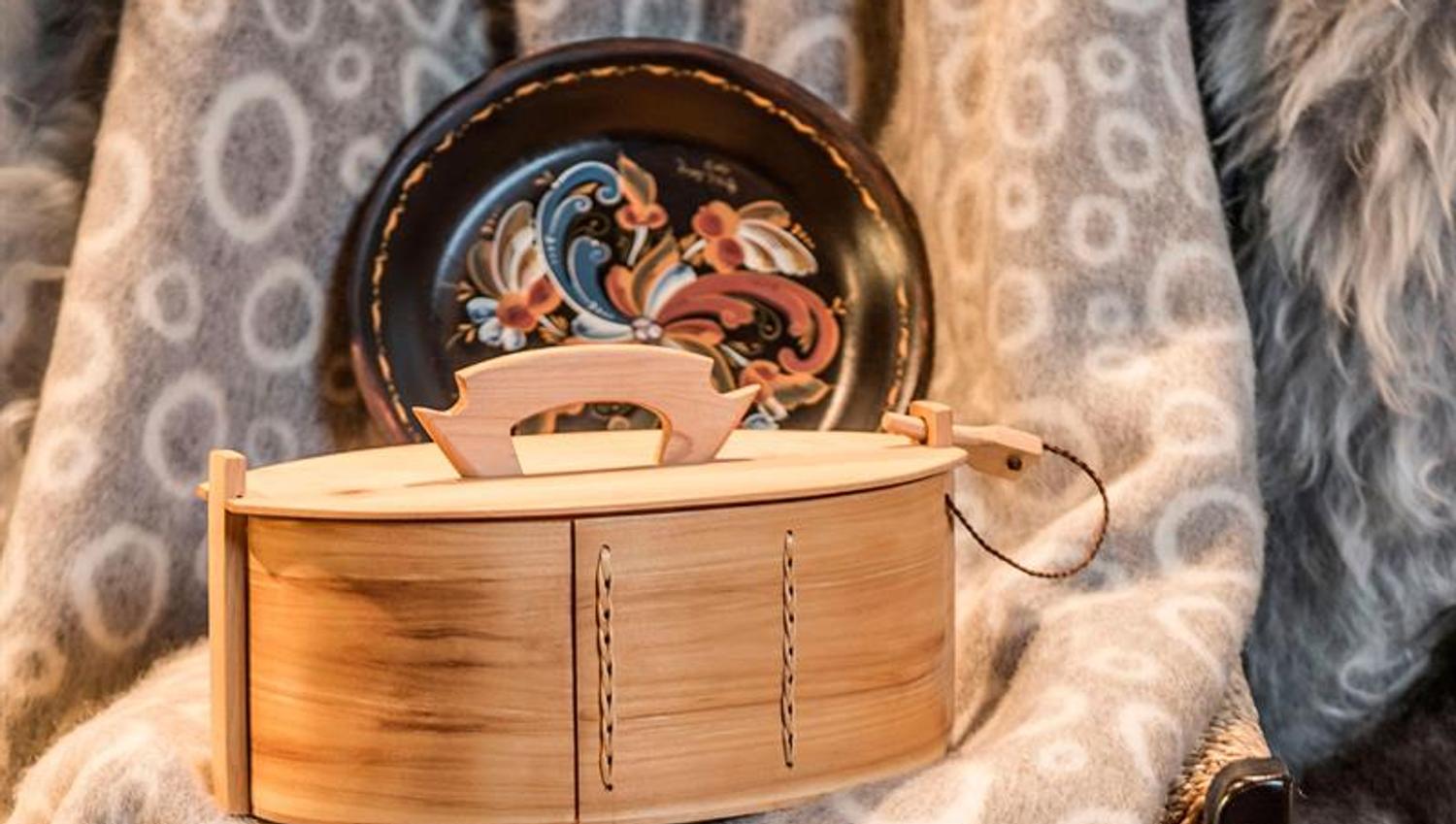 Detaljbilde av treboks og en håndmalt tallerken i tre.