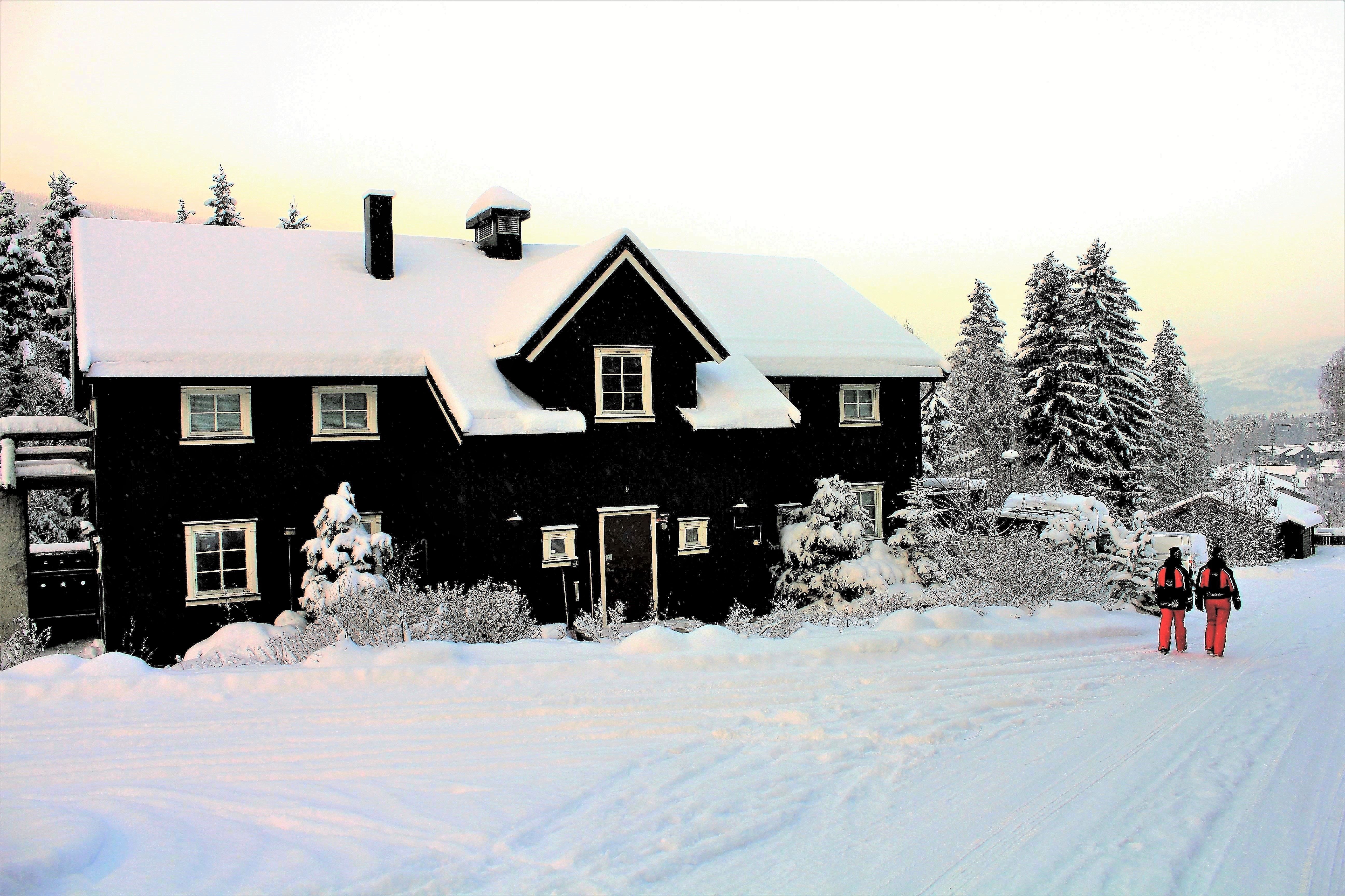 The barn is a large cabin with snow on the ground.