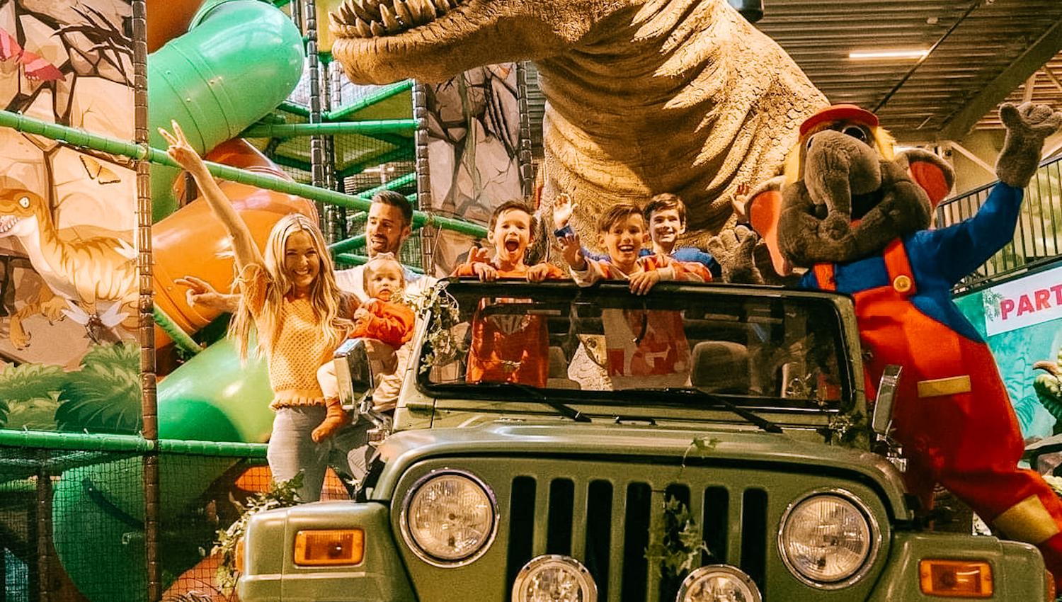 foto, en jeep med mange barn i, bilen står i et lekeland