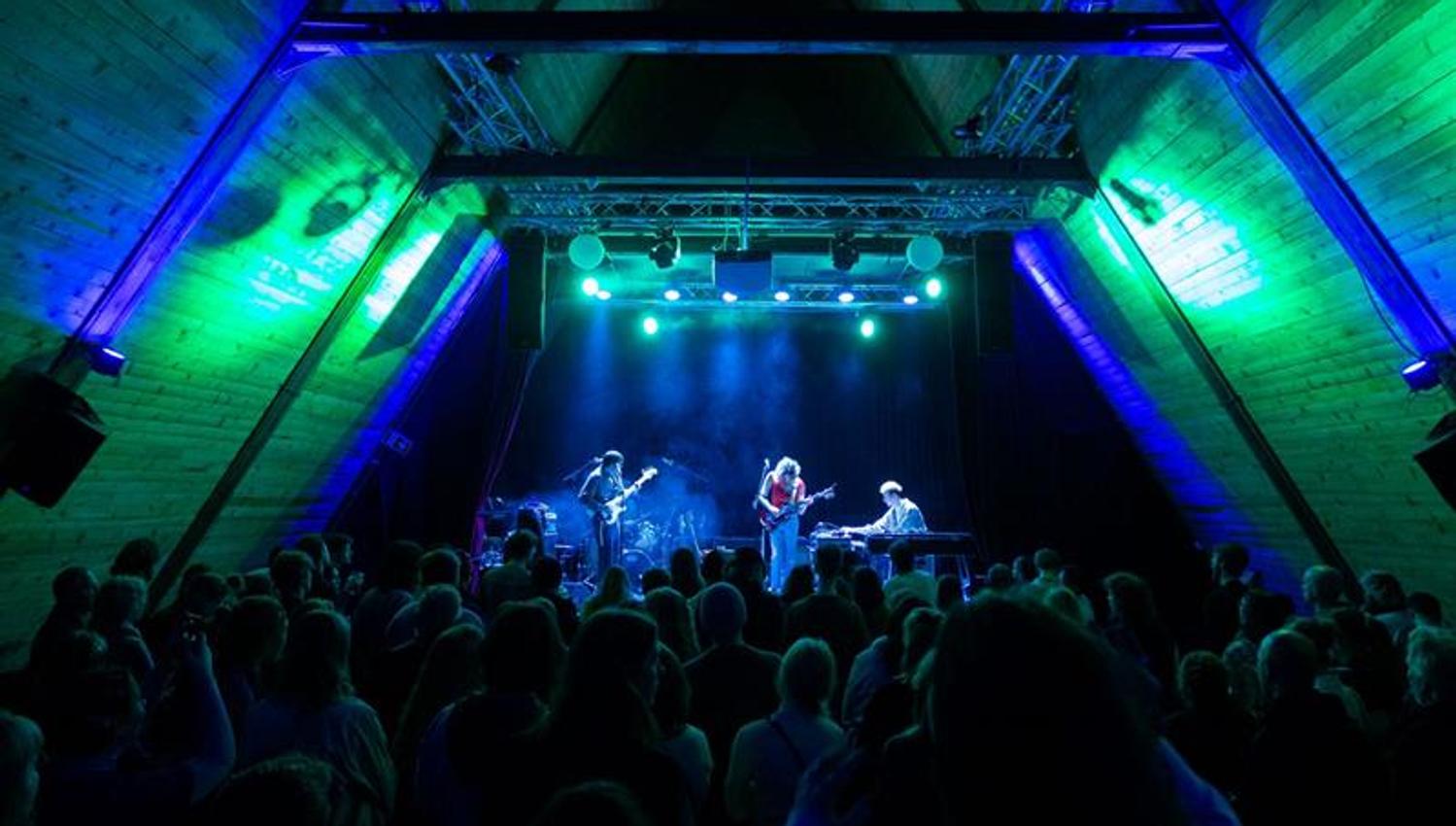artists on stage and full audience area during a concert at SALT