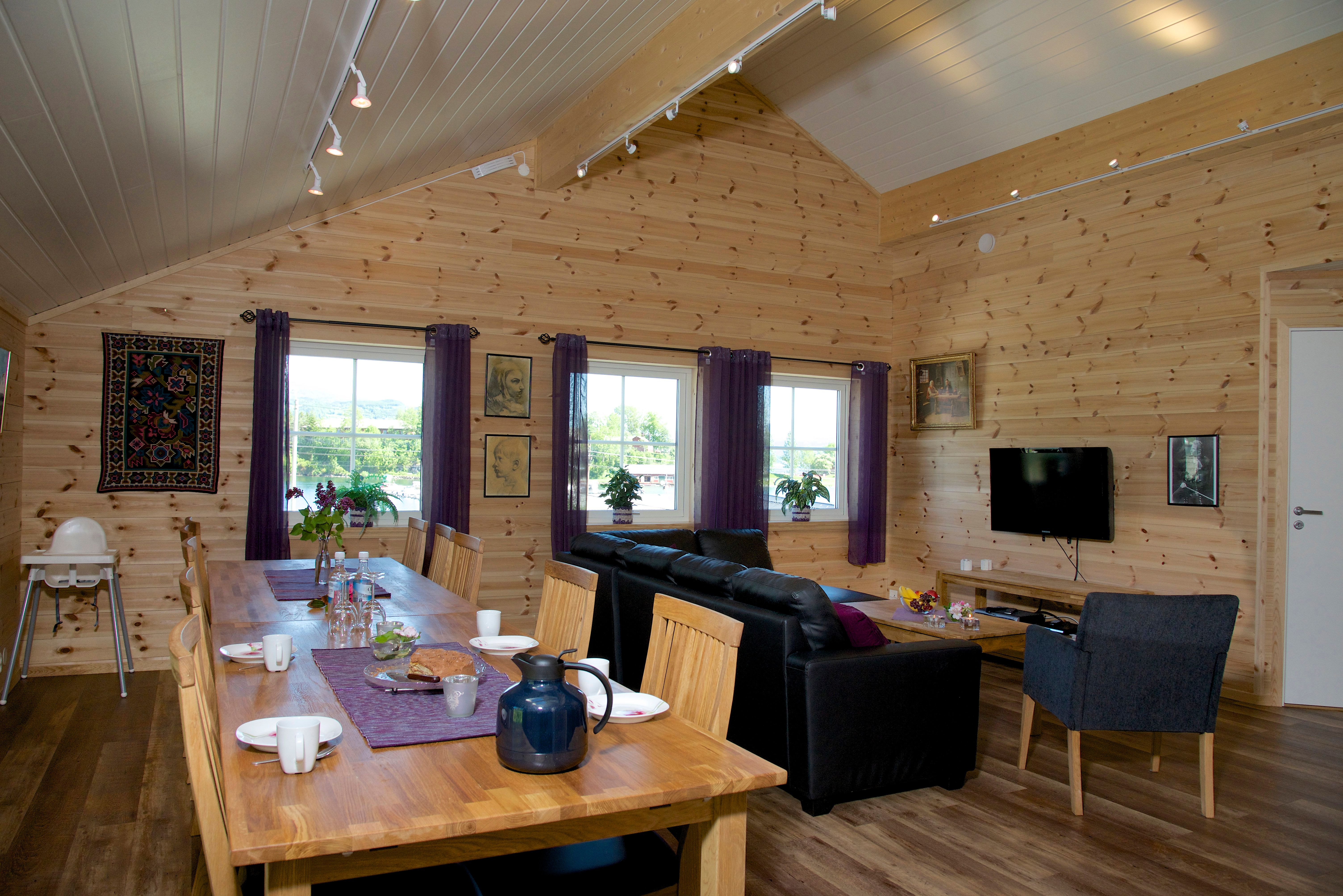 Triveleg allrom med lang spisebord, sofakrok og TV hjå Vågen Rom og Hytteutleige i Hardanger.