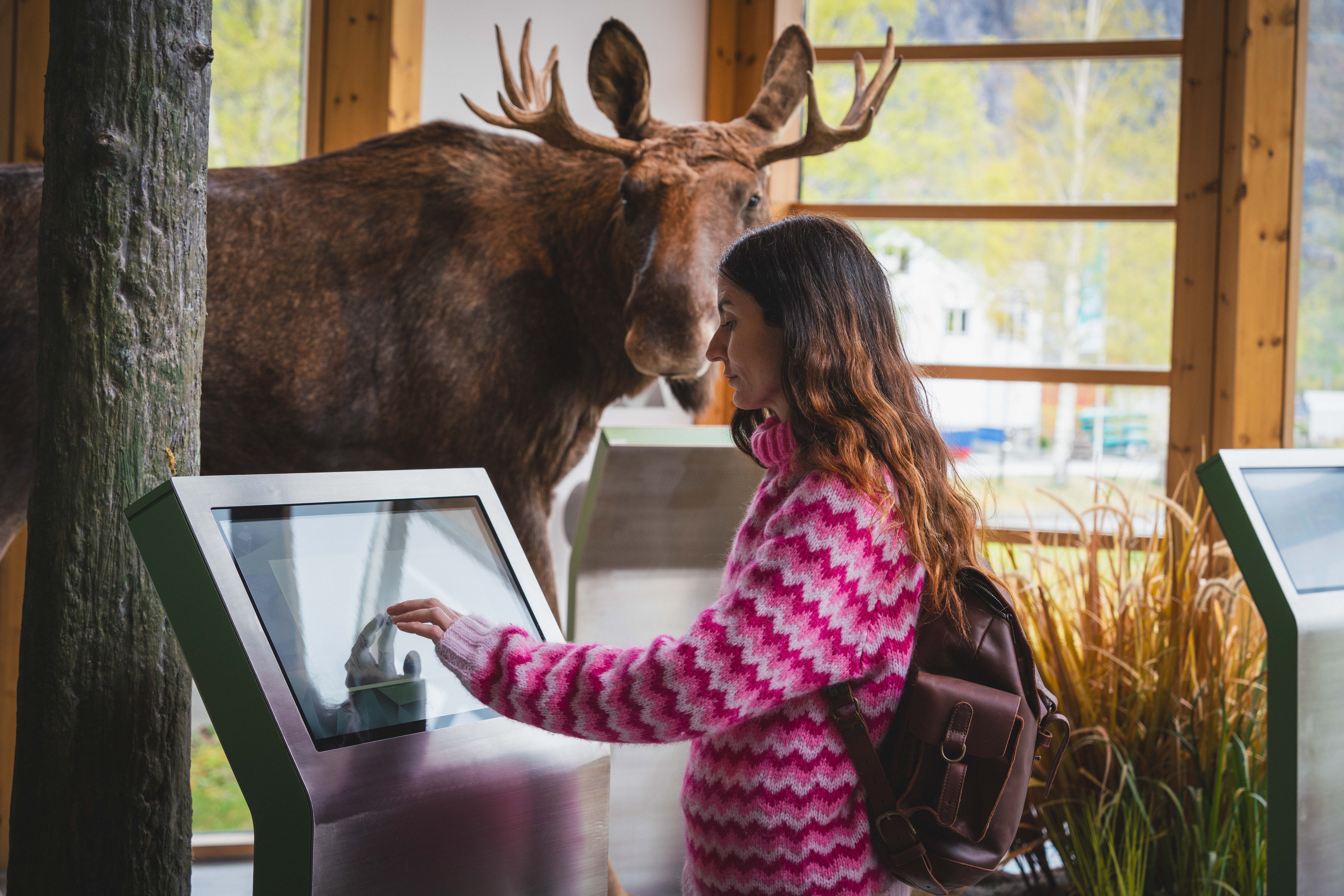 A woman getting information from a touchscreen at the Nature Center.