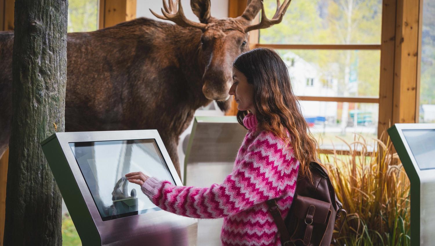 A woman getting information from a touchscreen at the Nature Center.