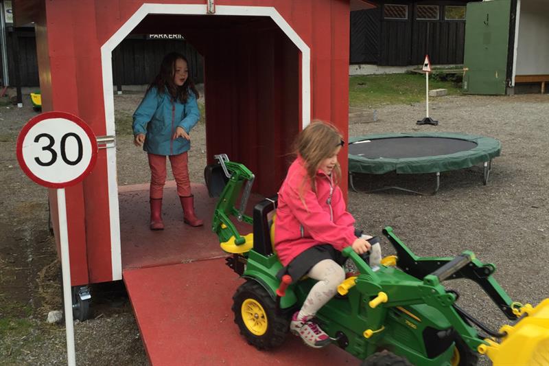 Barn som leker med en traktor.