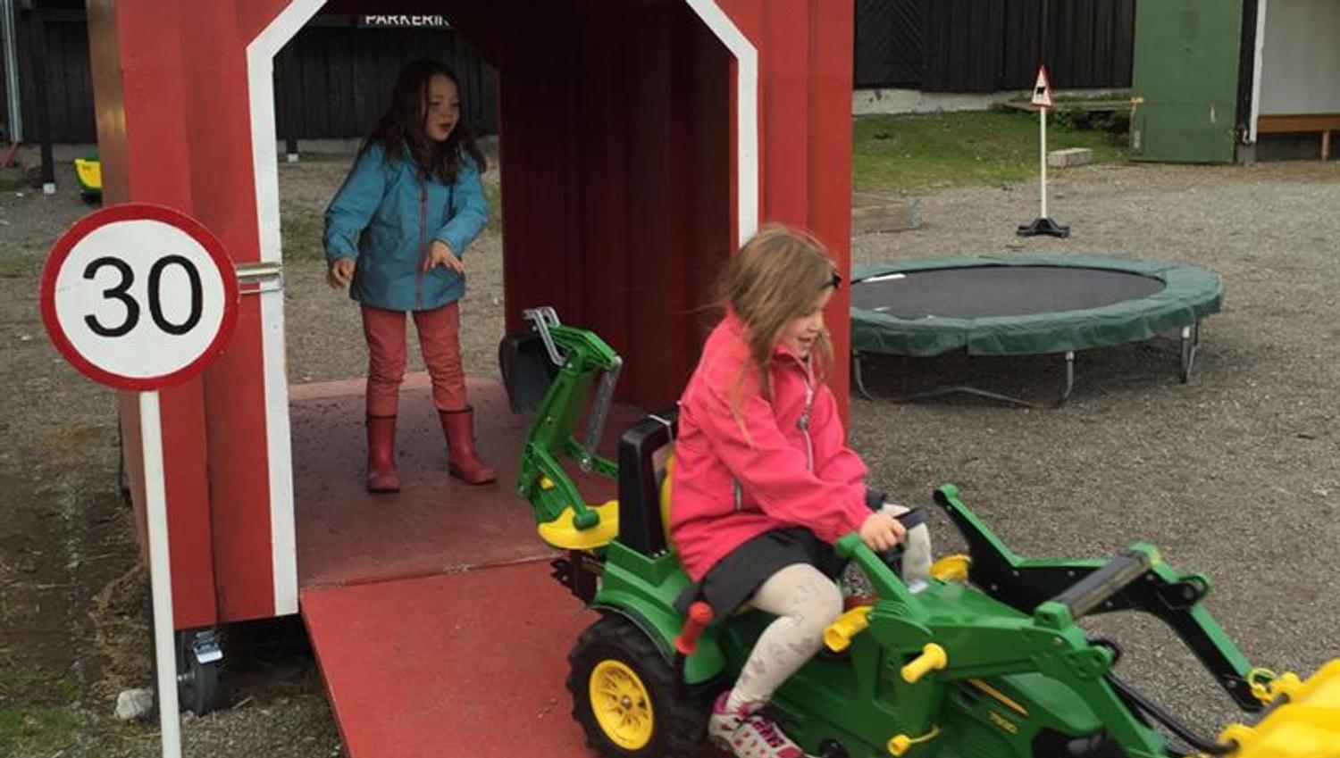 Barn som leker med en traktor.