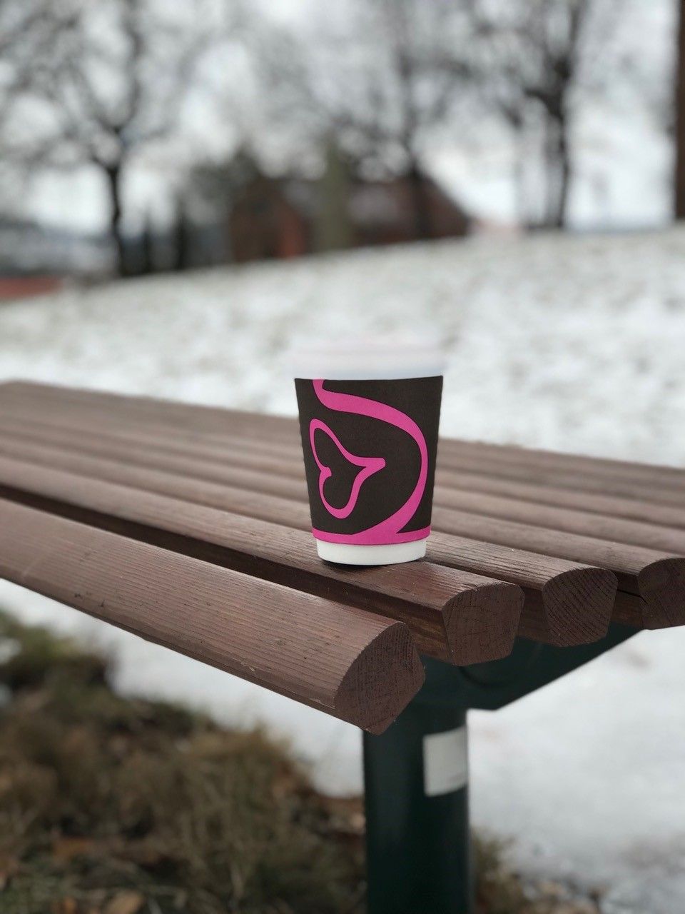 Pappkopp med kaffe ute på en benk på vinteren