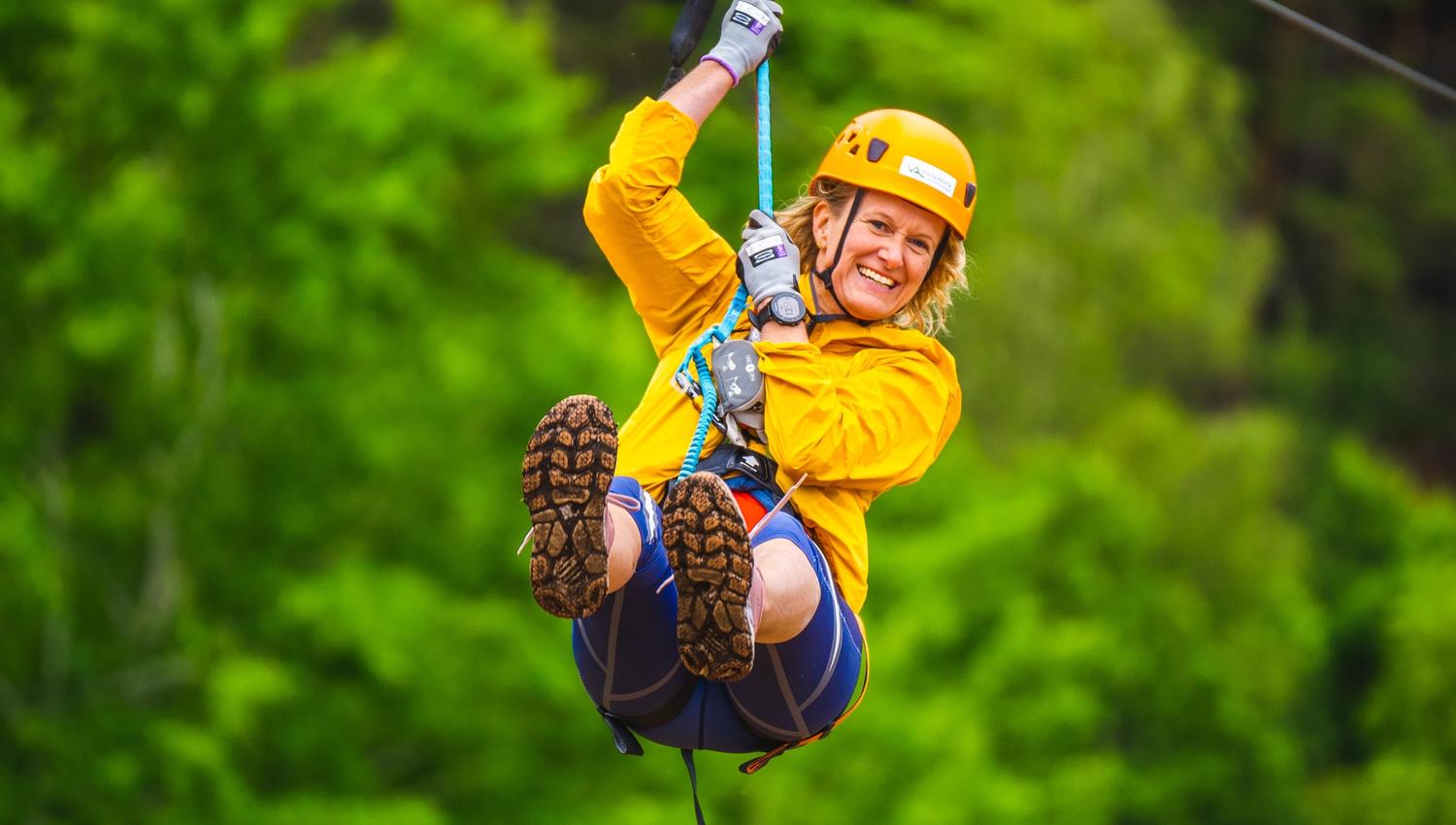 Kvinne på vei ned i zip-linen i Via ferrata Haldenkanalen