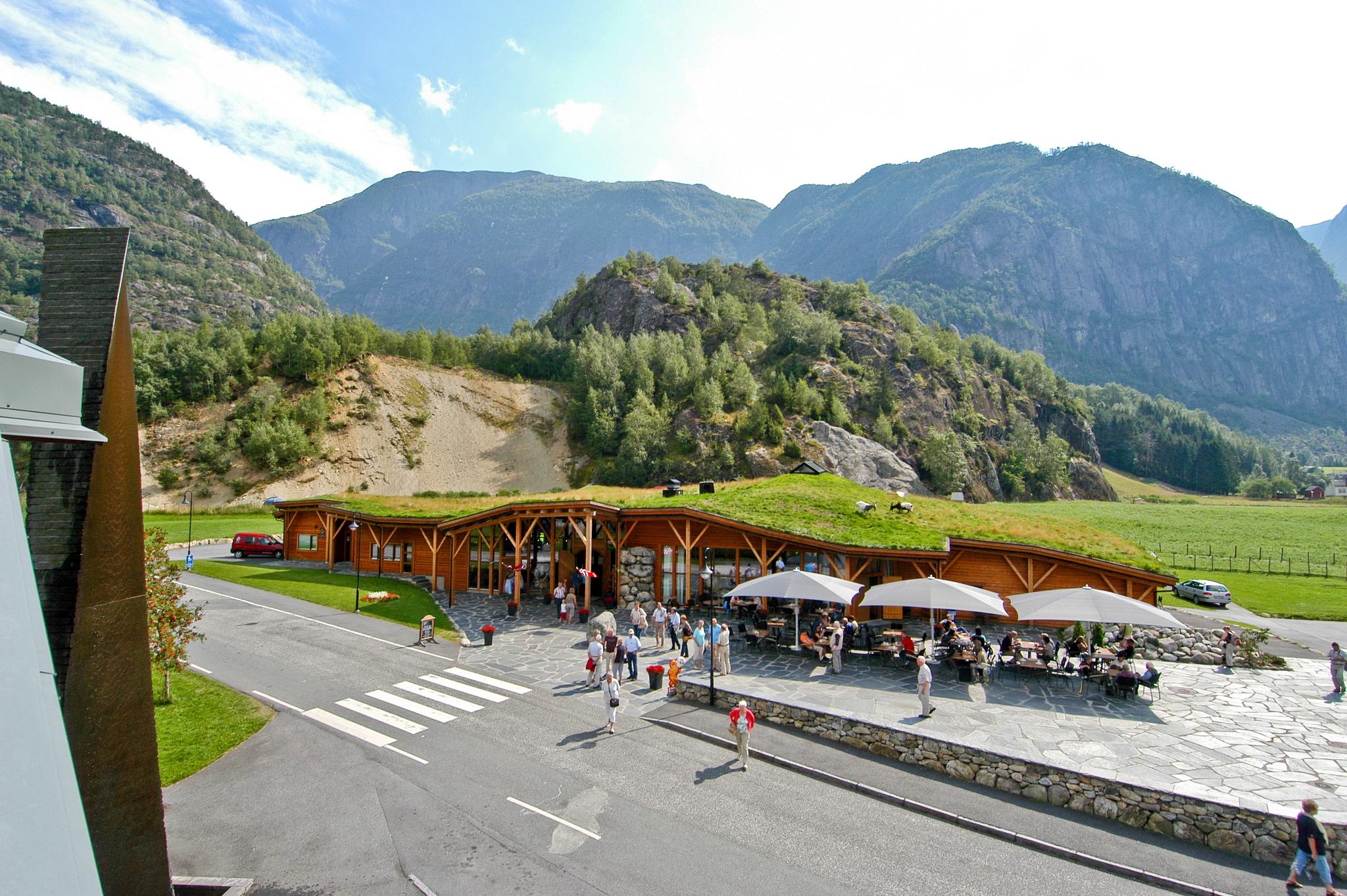 Hardangerviddahallen, a wooden buiding with grass and goats on the roof, seen from the outside.