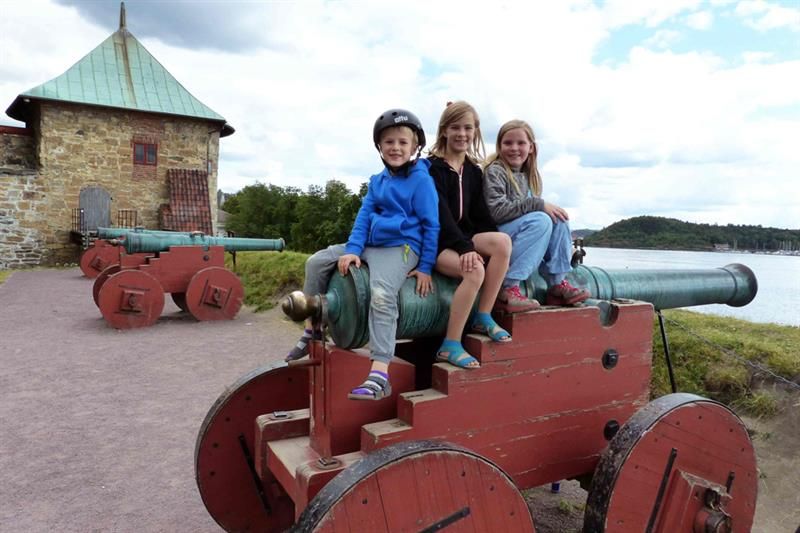 Tre barn som sitter på en kanon.