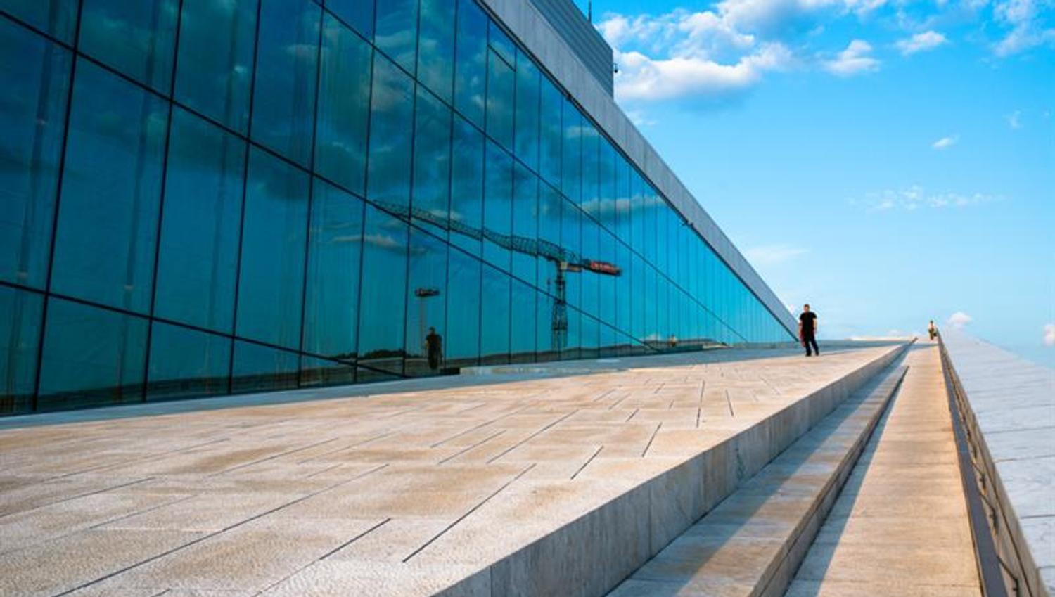 Eksteriørbilde av operaen med de store glassvinduene på den ene siden.