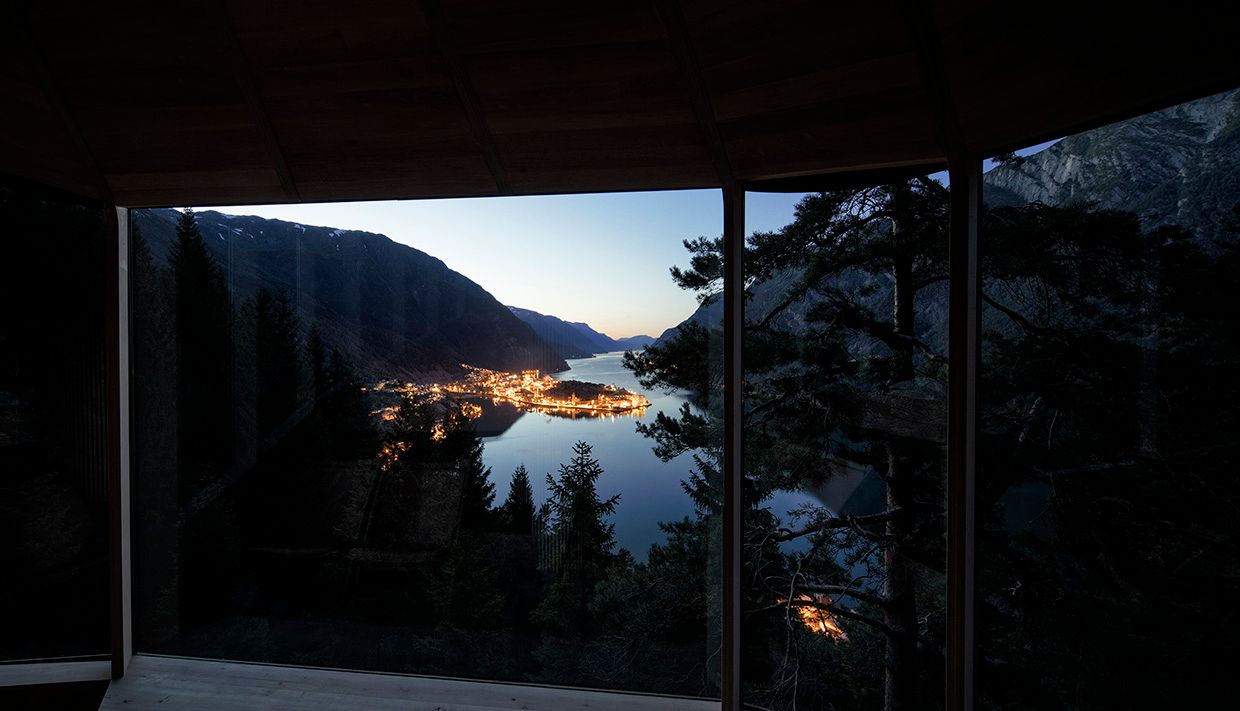 Magisk kveldsutsikt frå Woodnest tretopphytte – lysa frå Odda speglar seg i fjorden.