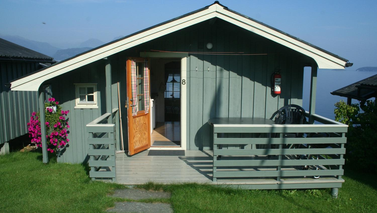 Opna hytte på Oddland Camping med innsyn til stova og utsikt over Hardangerfjorden.