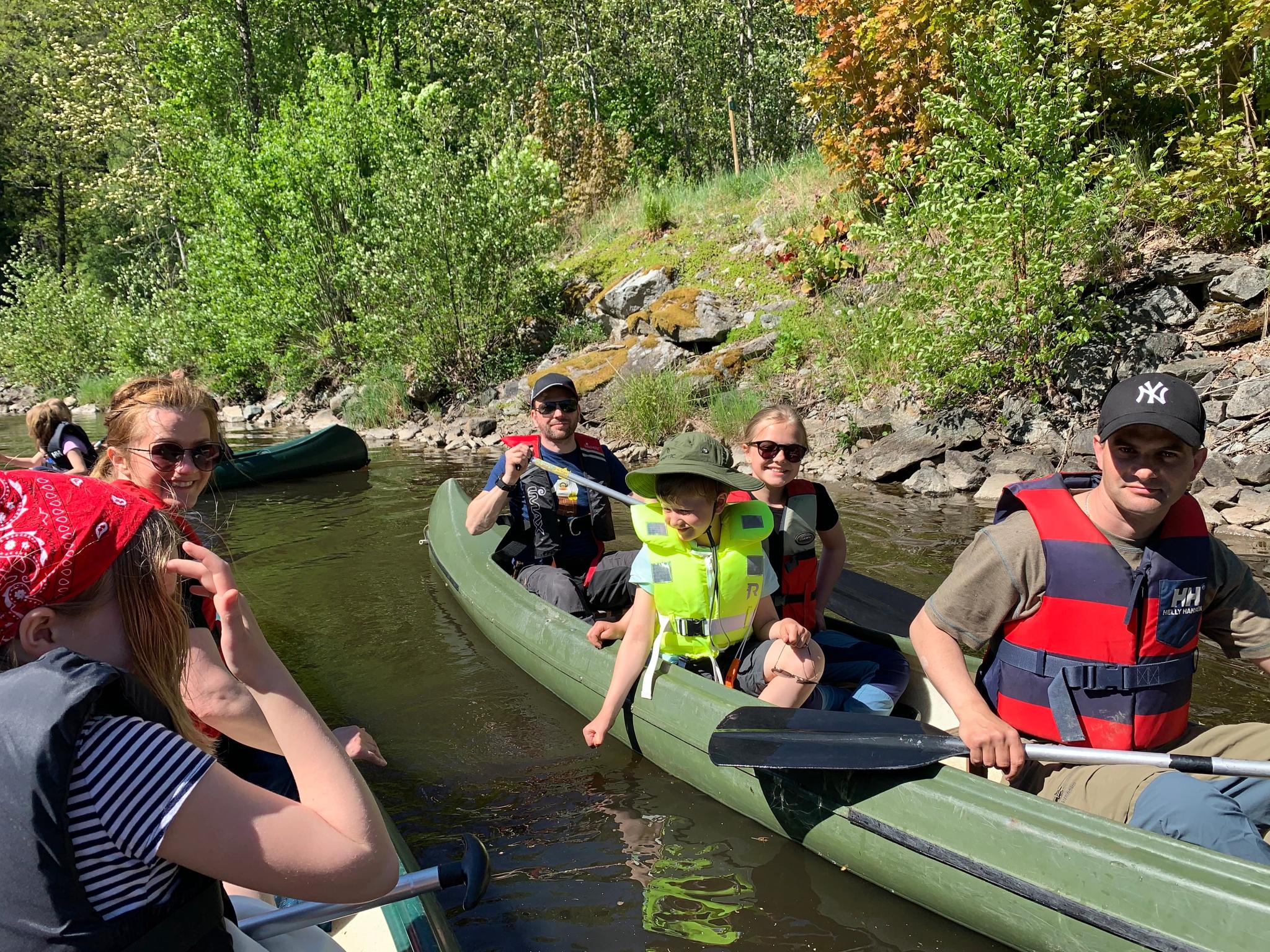 Barn og voksne som sitter i kano