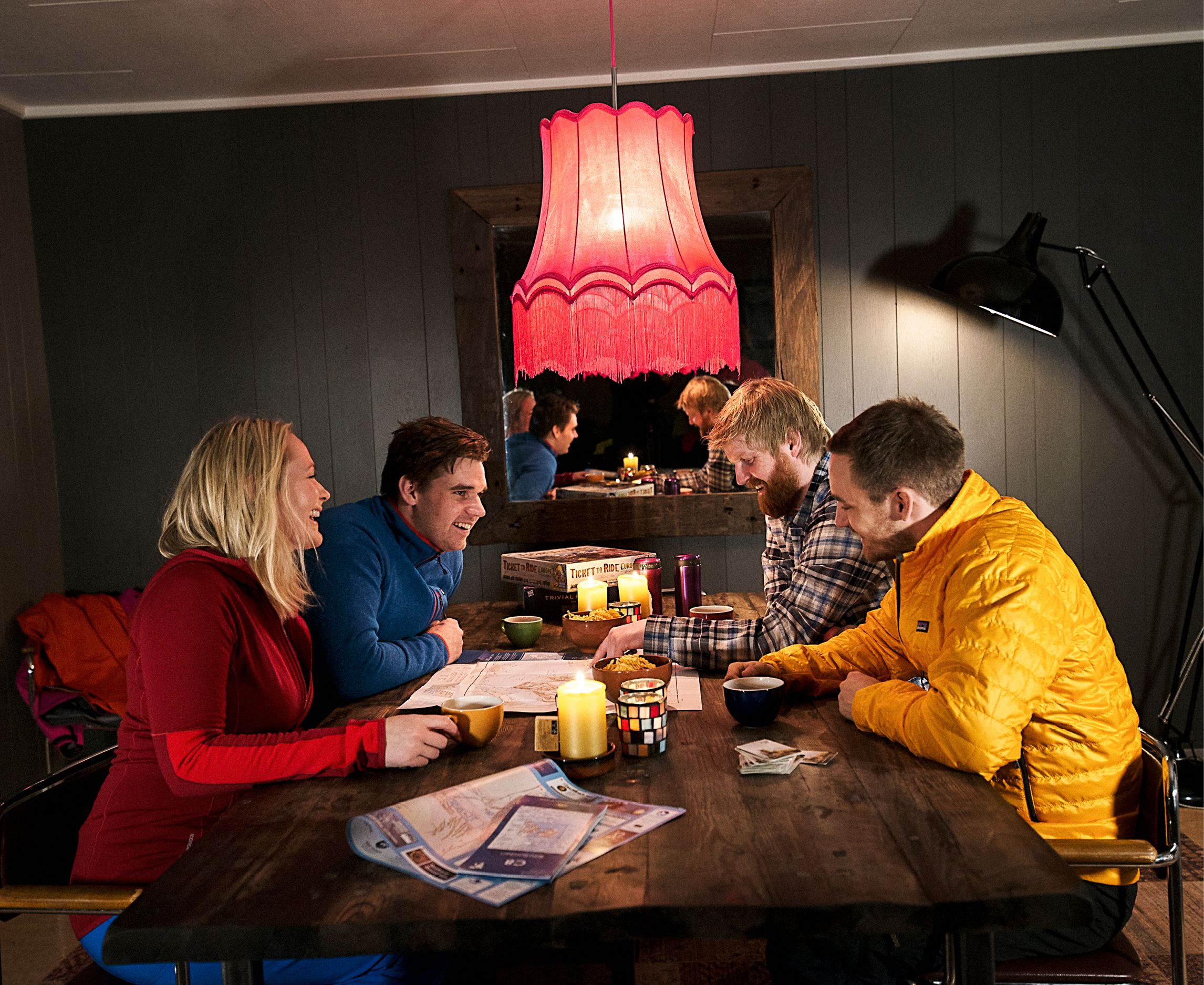 Four guests sitting around a table looking at a map of Svalbard in a room with dimmed lights