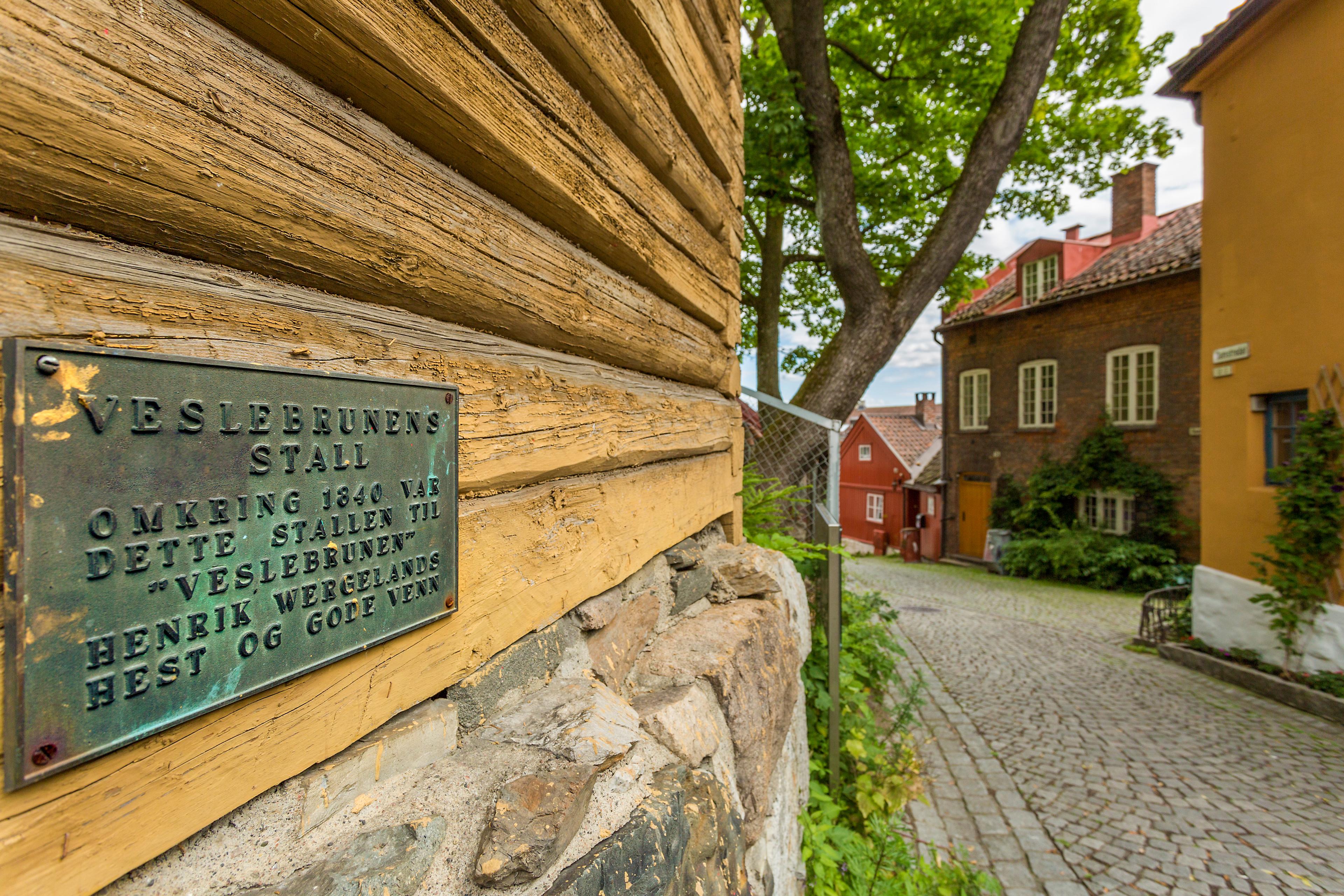 A plaque on an old, yellow wooden house.