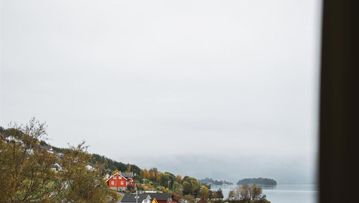 Utsikt frå rom på Rosendal Fjordhotel mot hardangerfjorden og sjarmerande hus