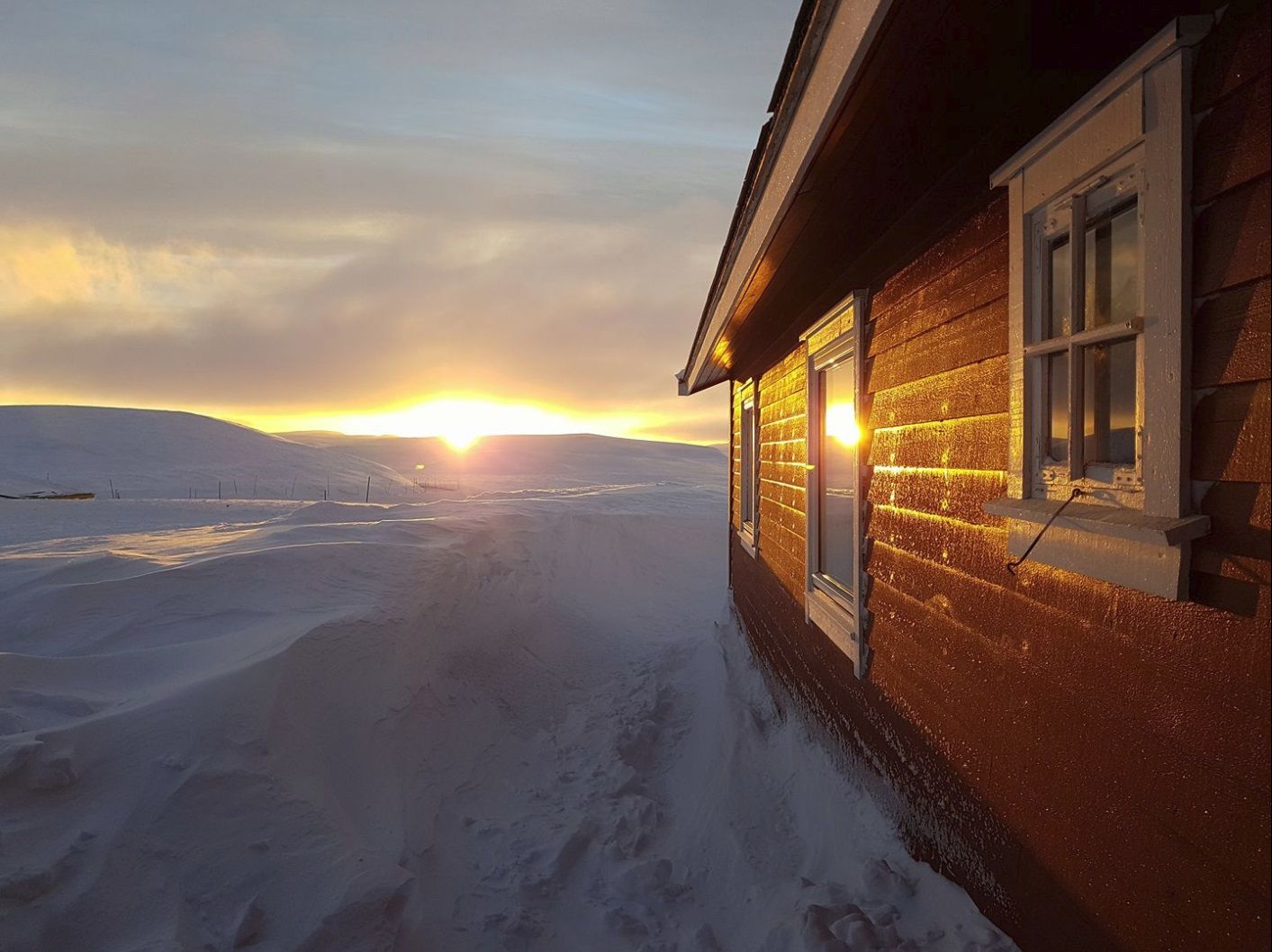 Dyranut Fjellstova under en vinter solnedgang.