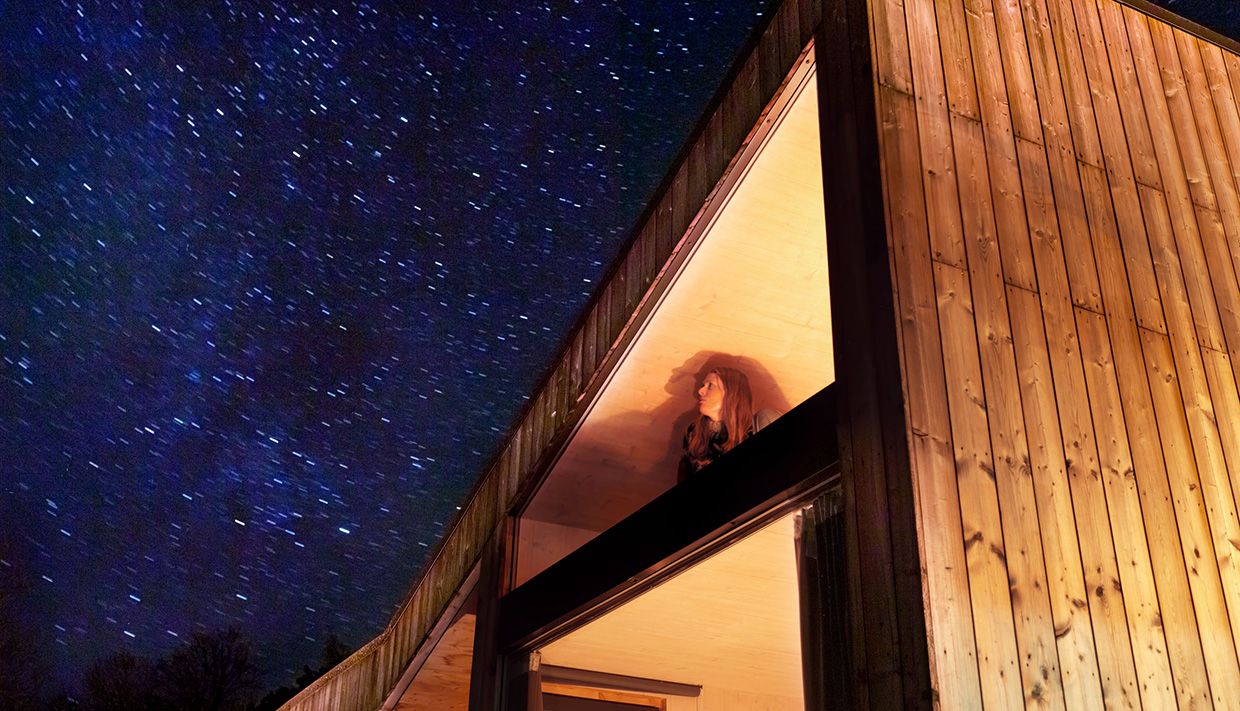 Guest looking up at the starry sky from inside the cabin near Hardangerfjord.