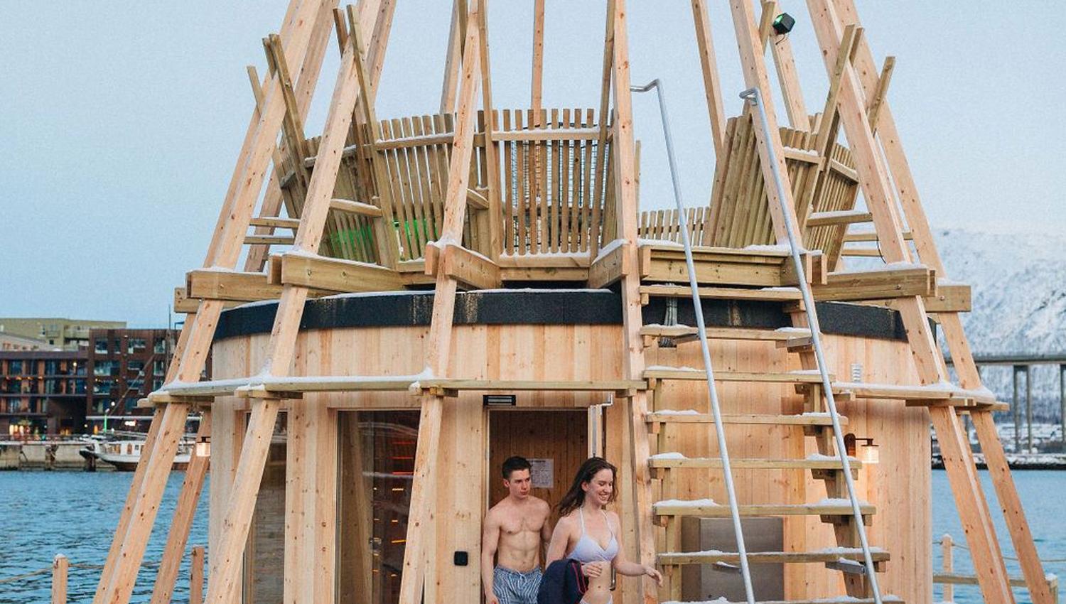 To personer på vei ut fra badstue i snøen