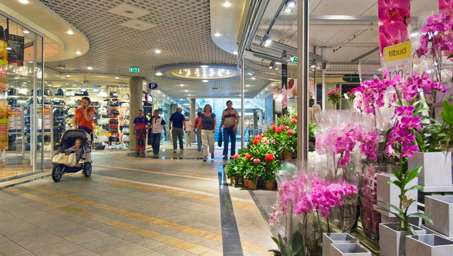 inne i shoppingsenteret ALTI Arendal med orkideer til høyre i bilde.
