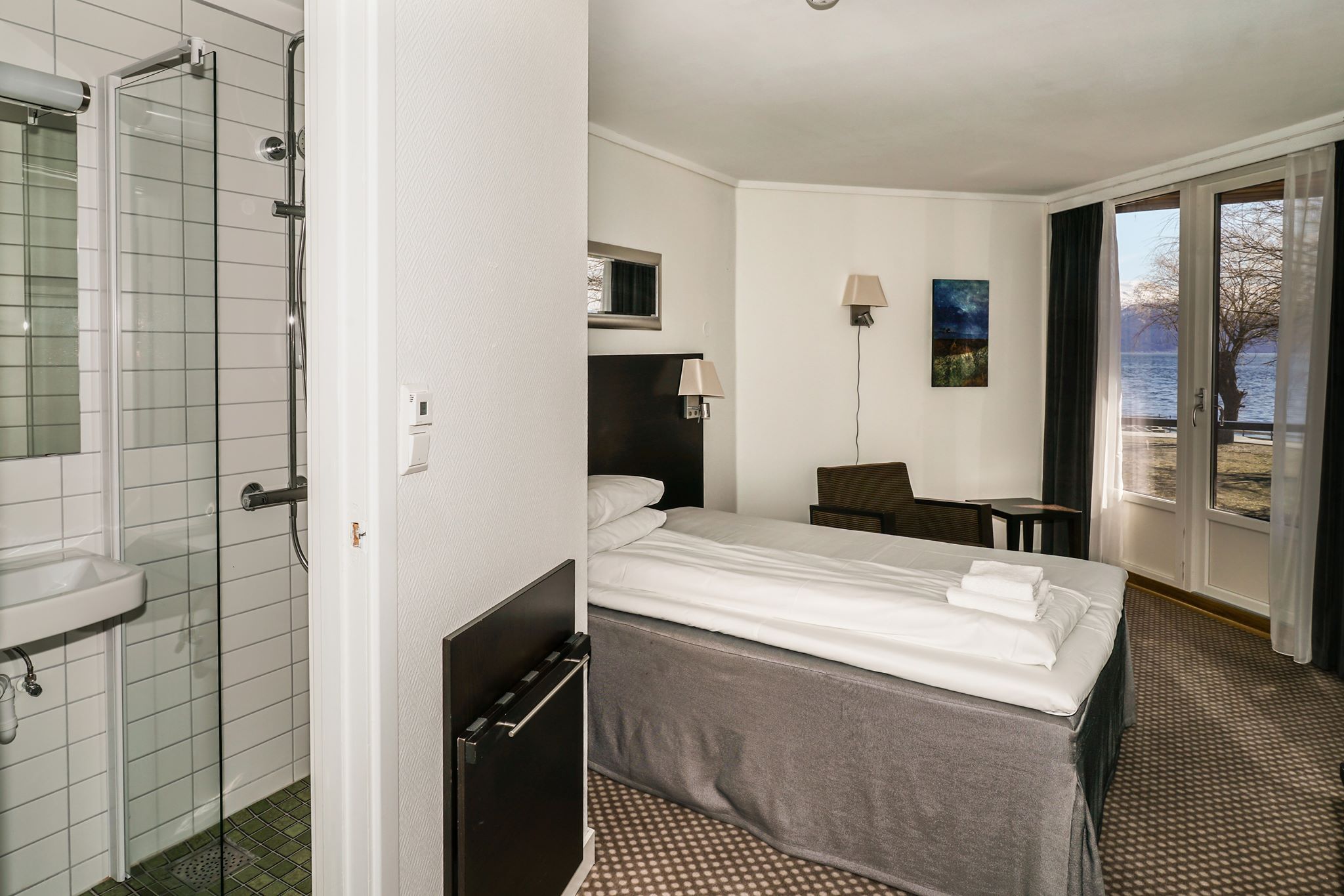 Hotellrom med enkeltseng og flott utsikt mot fjorden frå vindauget.